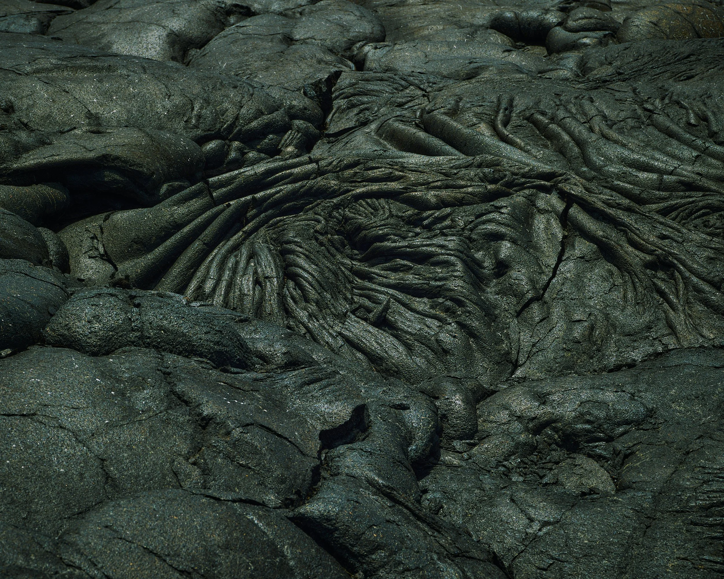 Close-up of dark, textured volcanic lava rocks with rough, twisted surfaces.
