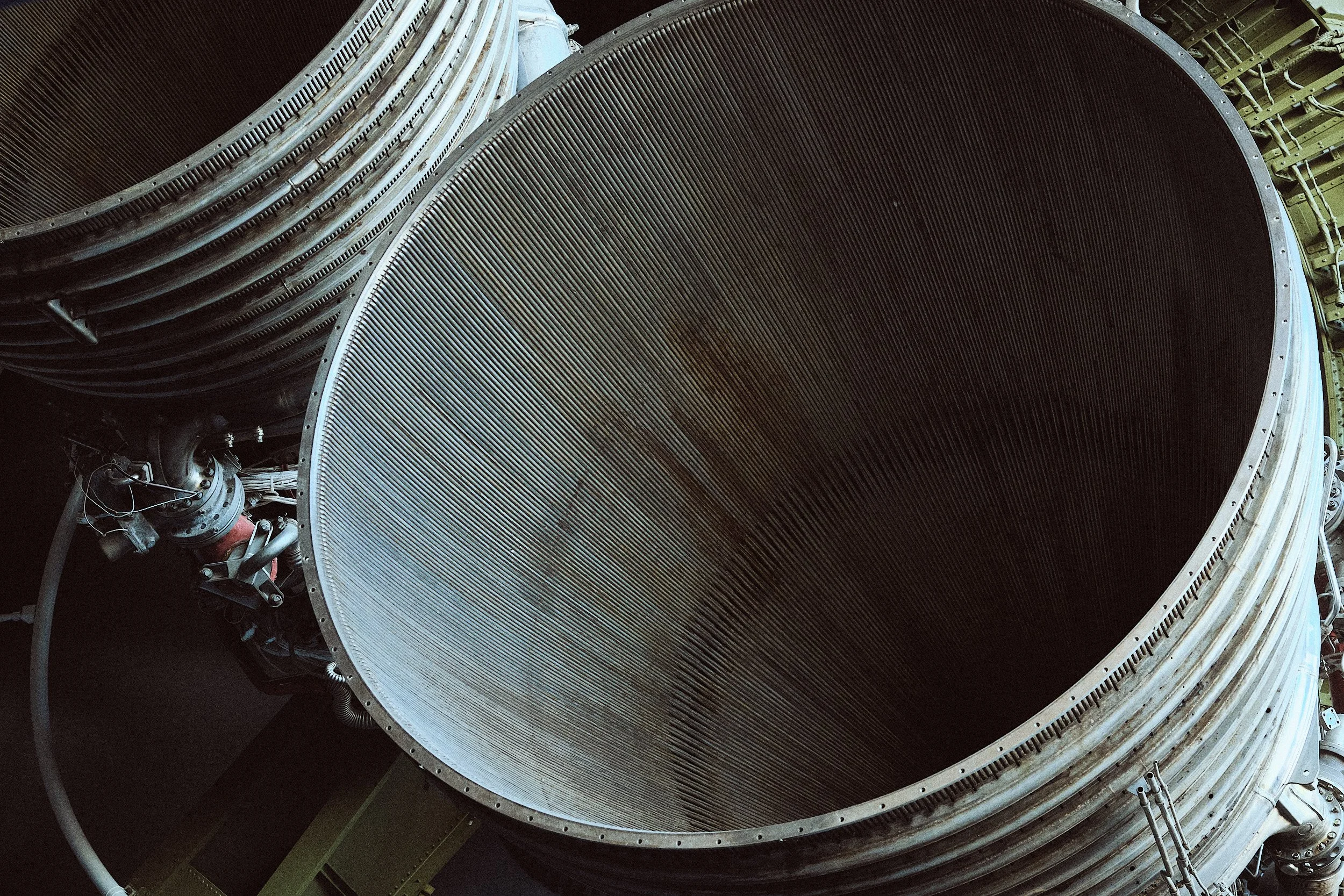 Close-up view of a large rocket engine nozzle with intricate mechanical components around it.