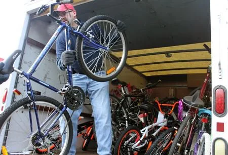 Todd Jones, secretary of Bikes for Kids, helps load up the trucks with bicycles of all colors and makes, headed for Long Island. (Photo by L.E. Agnelli)