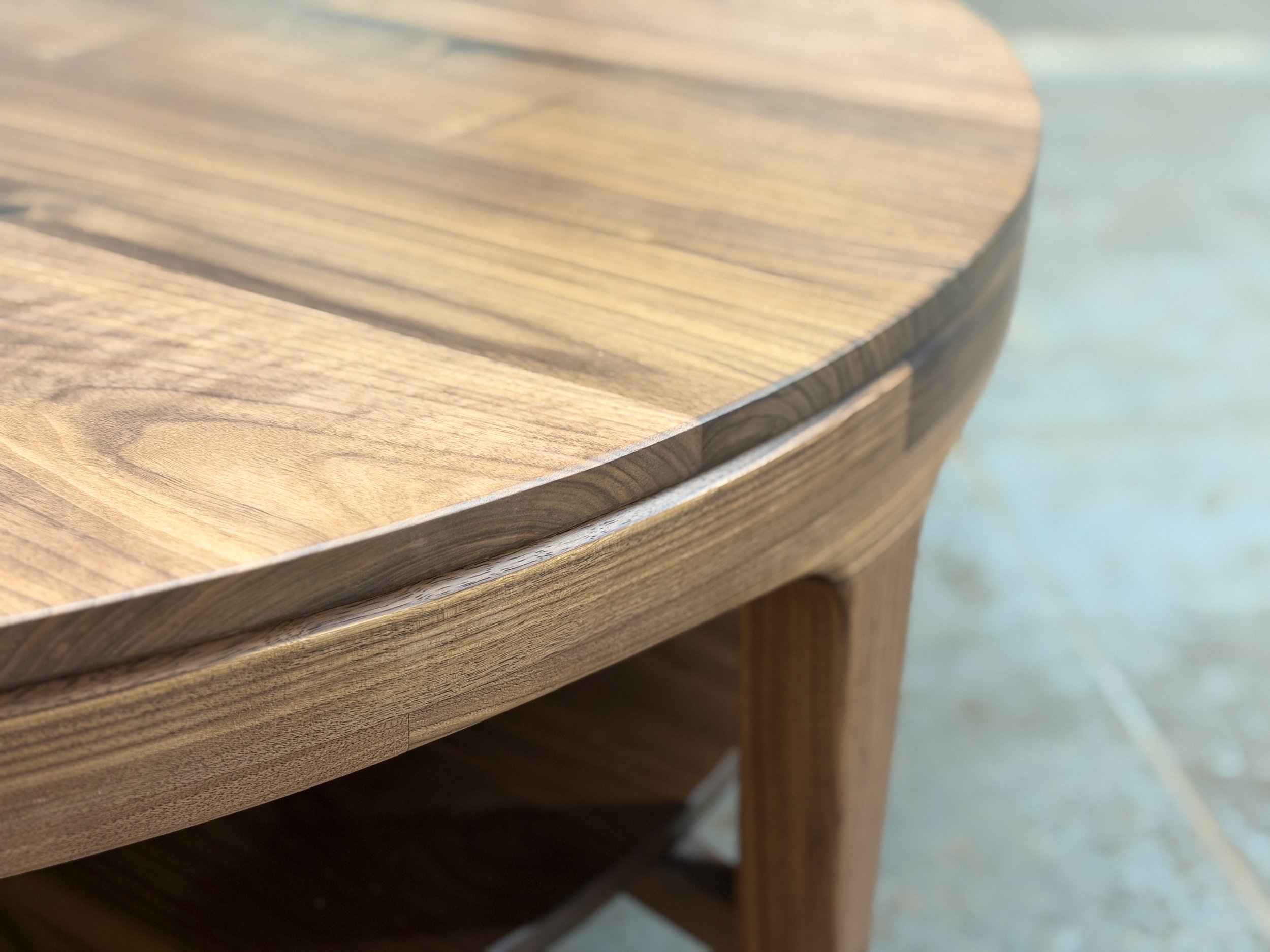 Close-up of a wooden table with a rounded edge.