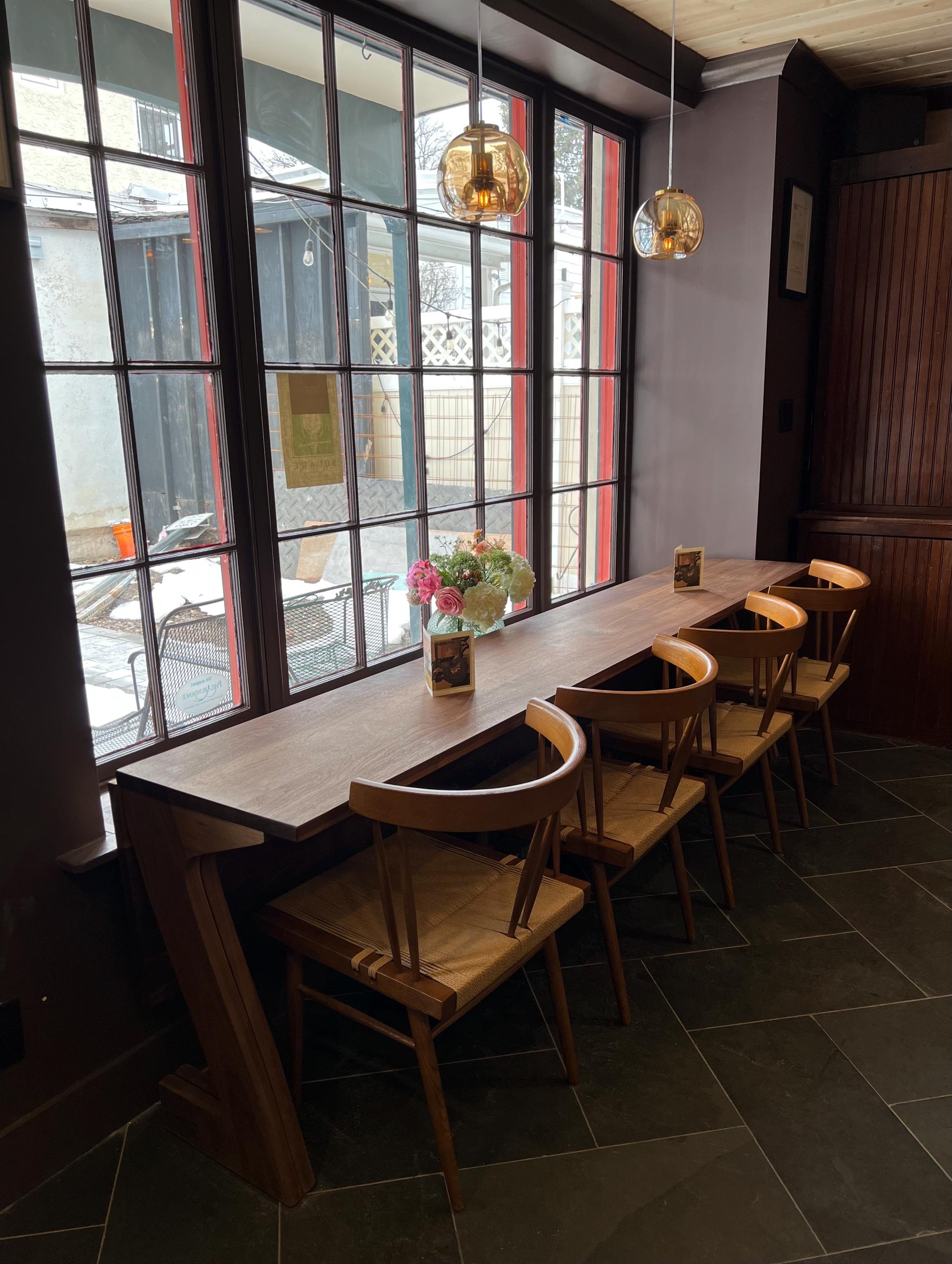 wood table and wood chairs with curved back placed against window