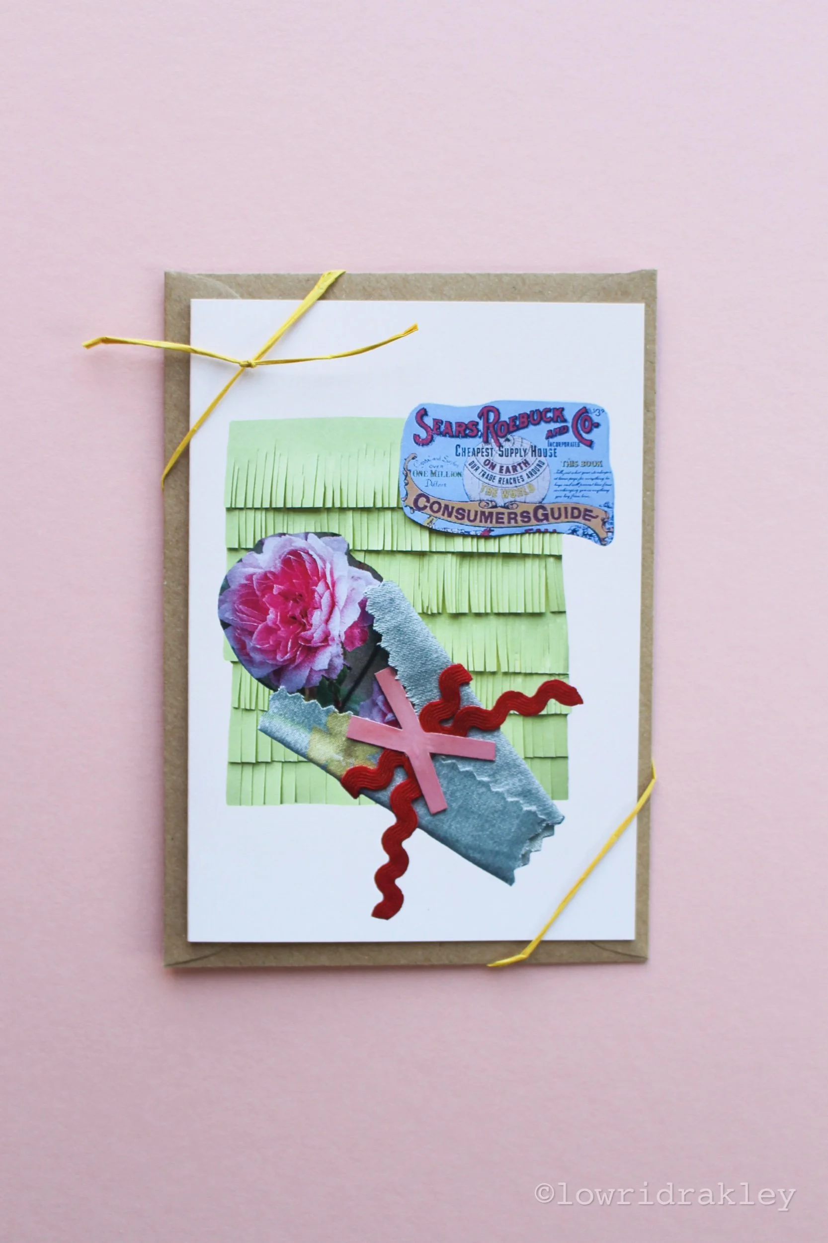 Handmade mixed-media greeting card titled "The Sears Roebuck Rose," featuring a vintage Sears Roebuck catalog label, a pink floral bloom, and red ric-rac trim on a green textured background.