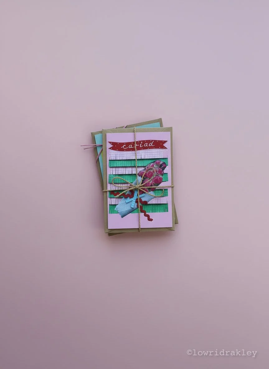 Bundle of three greeting cards tied with twine on a pink background, featuring a floral design.