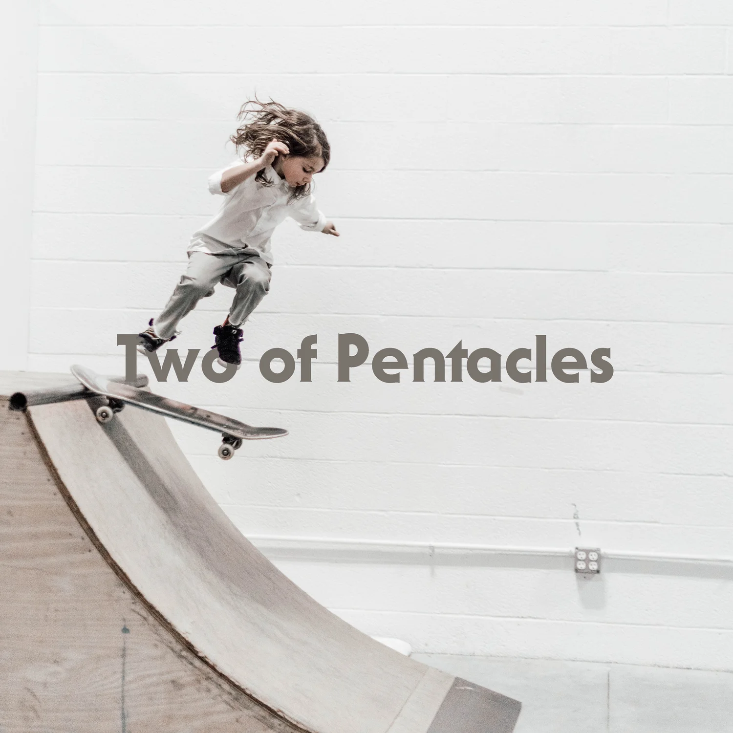A kid launches mid-air from a skateboard ramp, suspended in a moment of daring balance. The setting is raw and minimal, but the energy is kinetic.