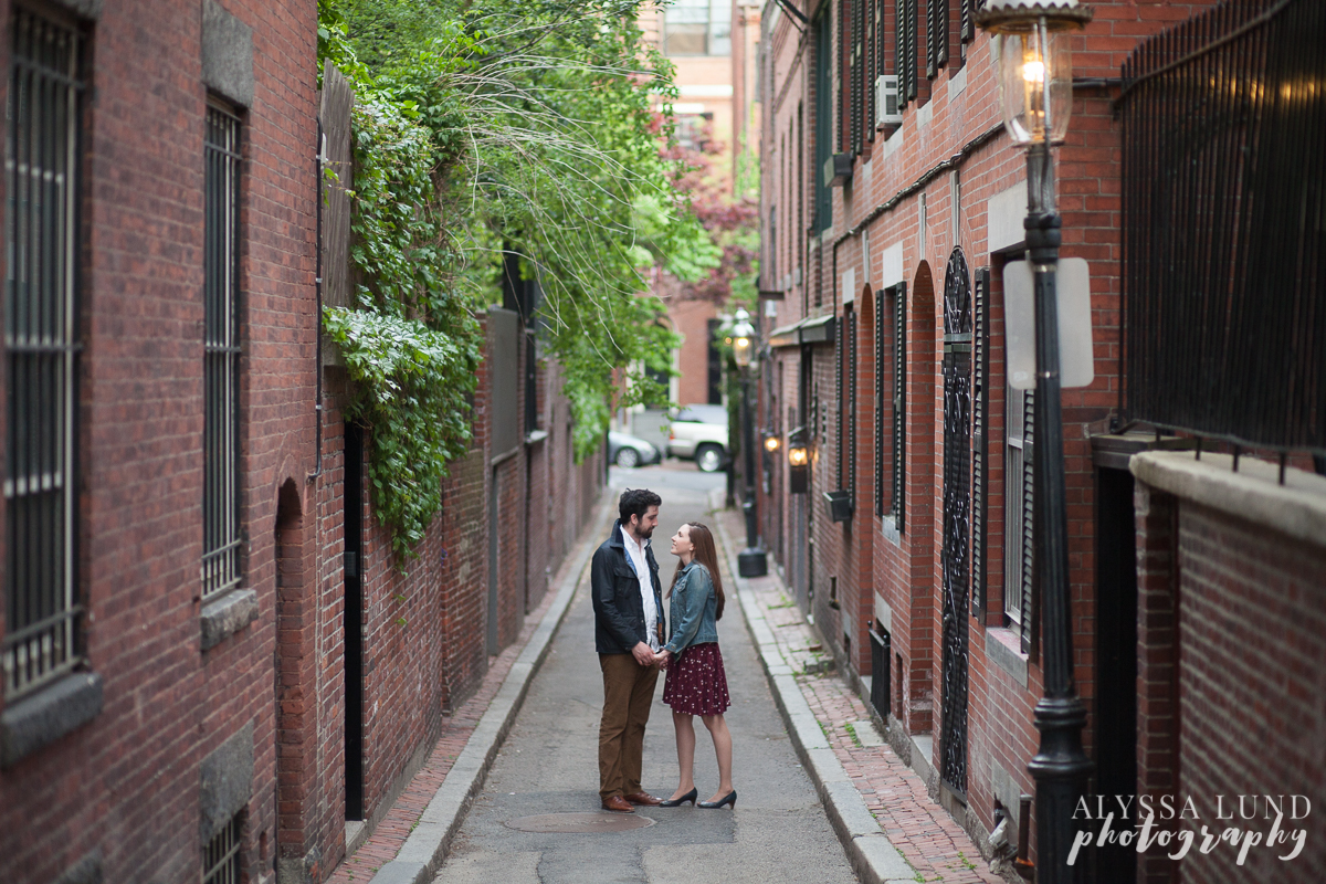 Engagement portrait holding hands in an alley