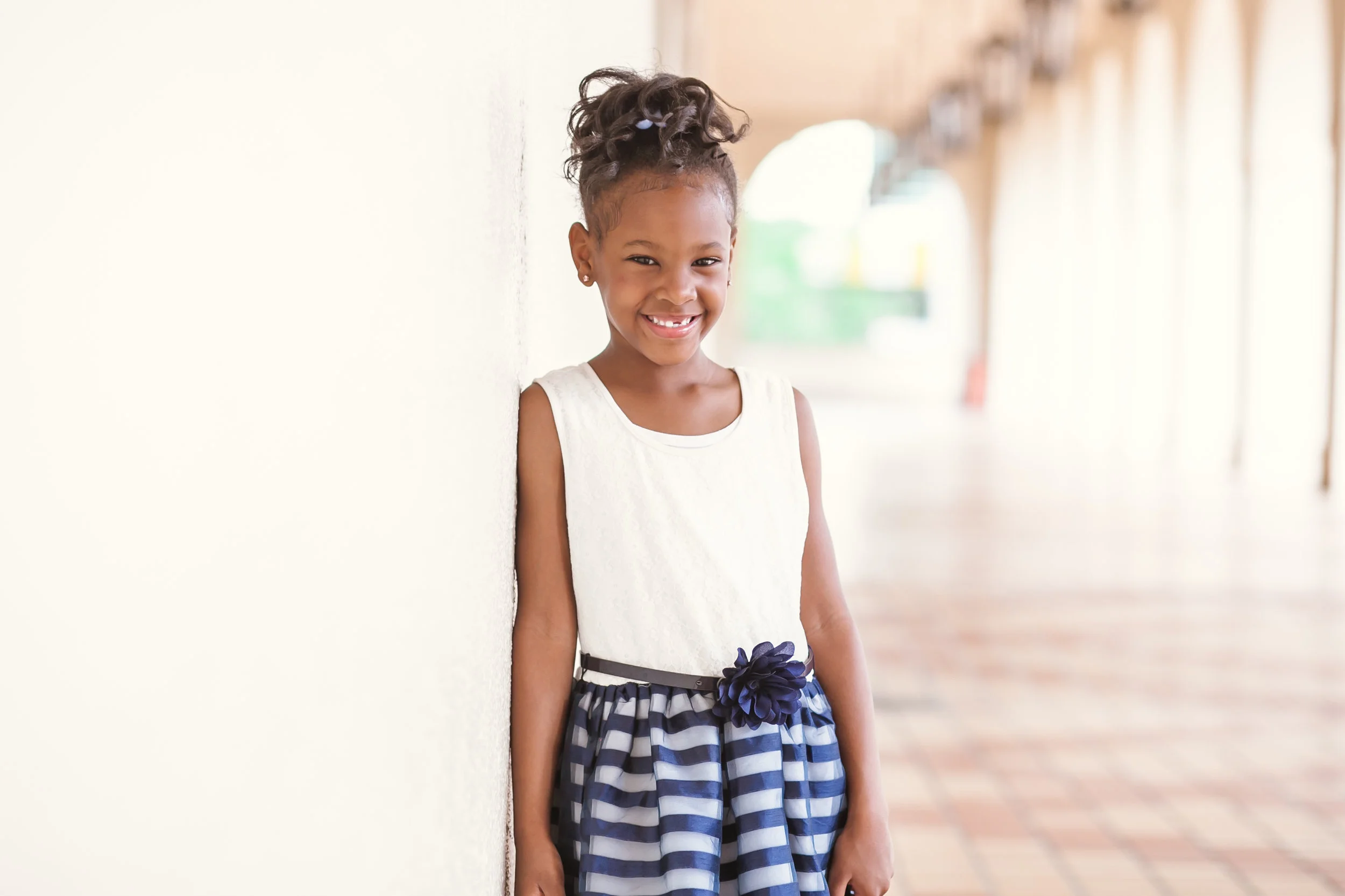 Happy girl leaning on wall at History Miami Museum gets adopted