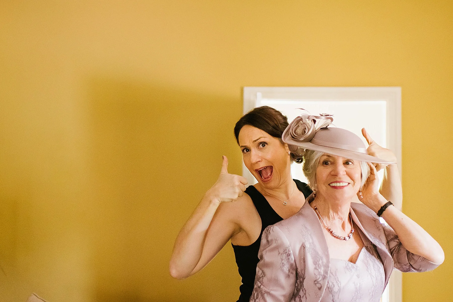 Bride giving thumbs up behind her mum