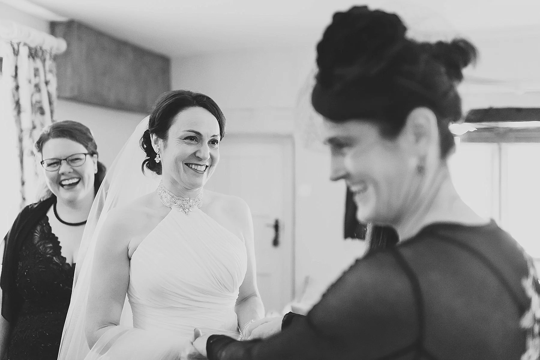 bride in her wedding dress laughing with her friends