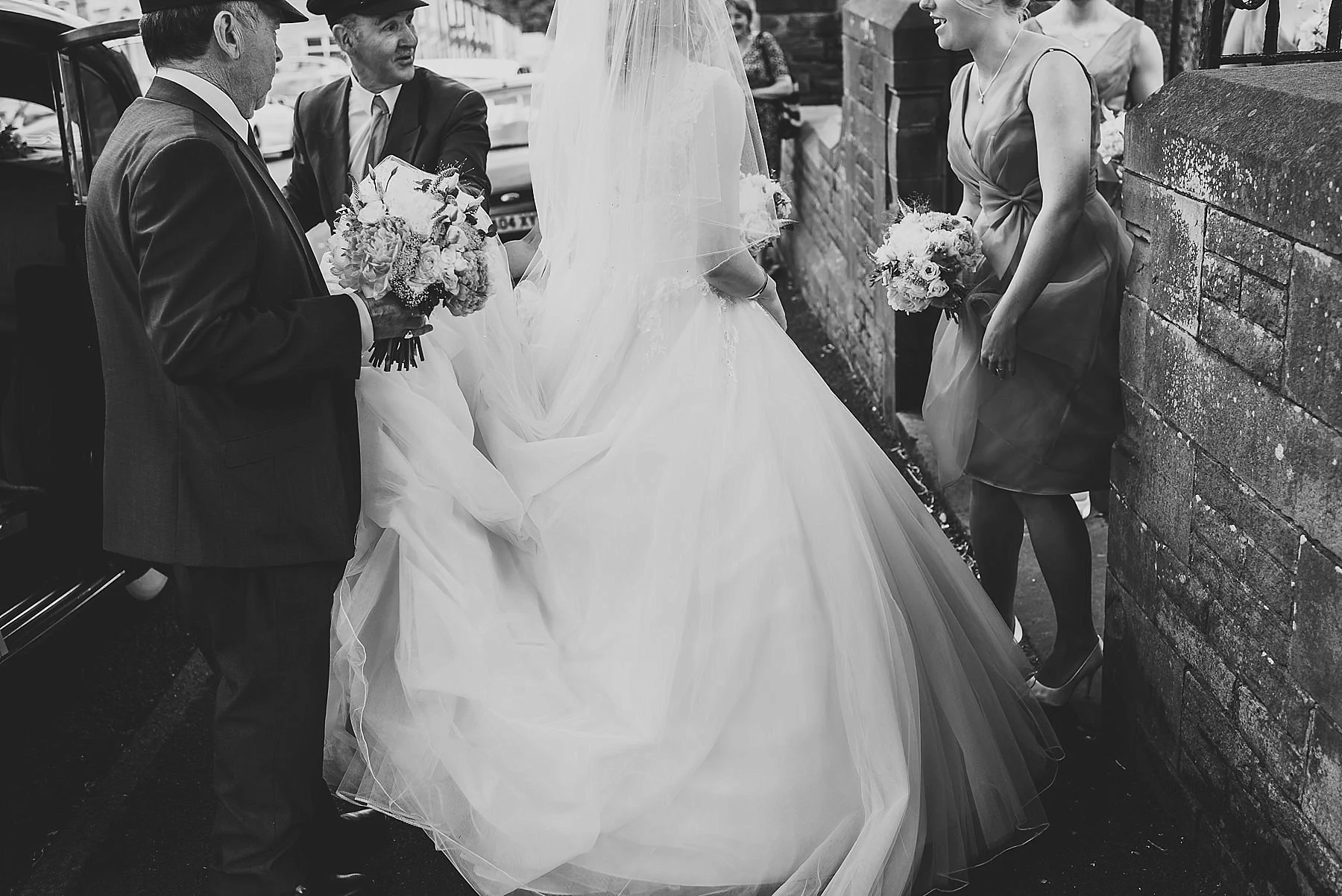 chauffeurs holding wedding dress