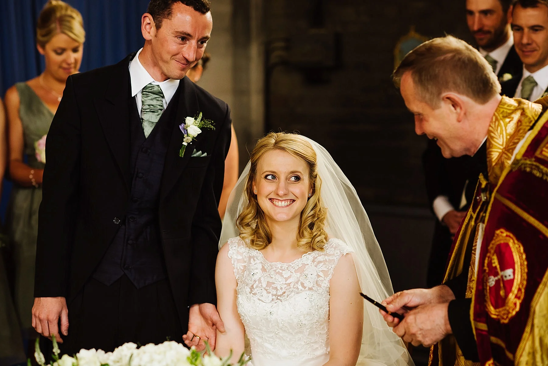 bride and groom smiling at the vicar
