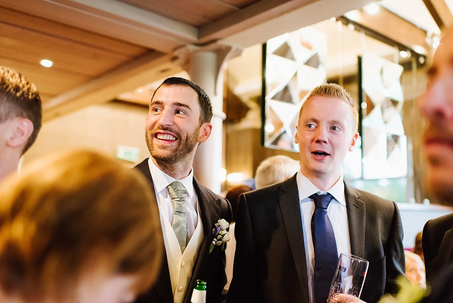 two male wedding guests looking interested