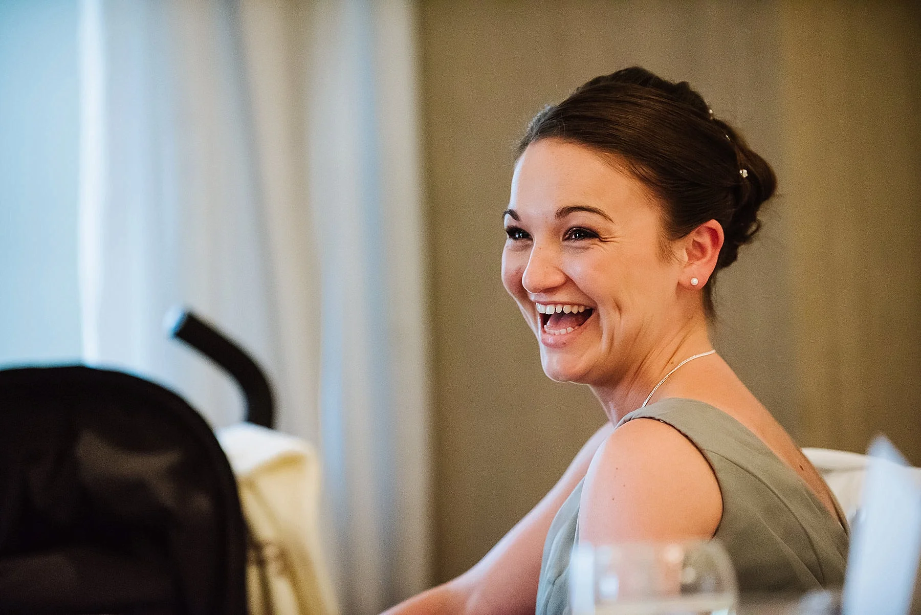 A natural shot of the bridesmaid laughing at the wedding