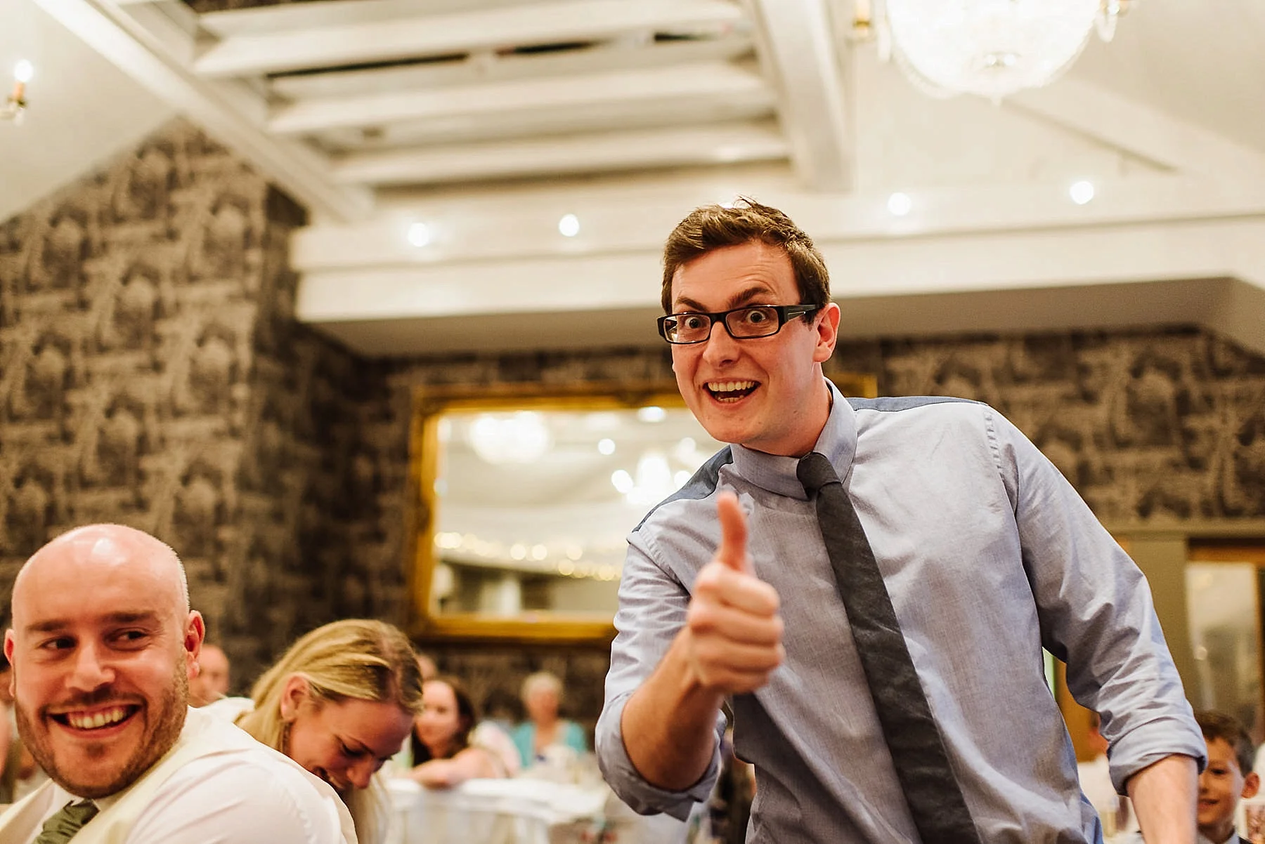 man looking at camera and giving thumbs up