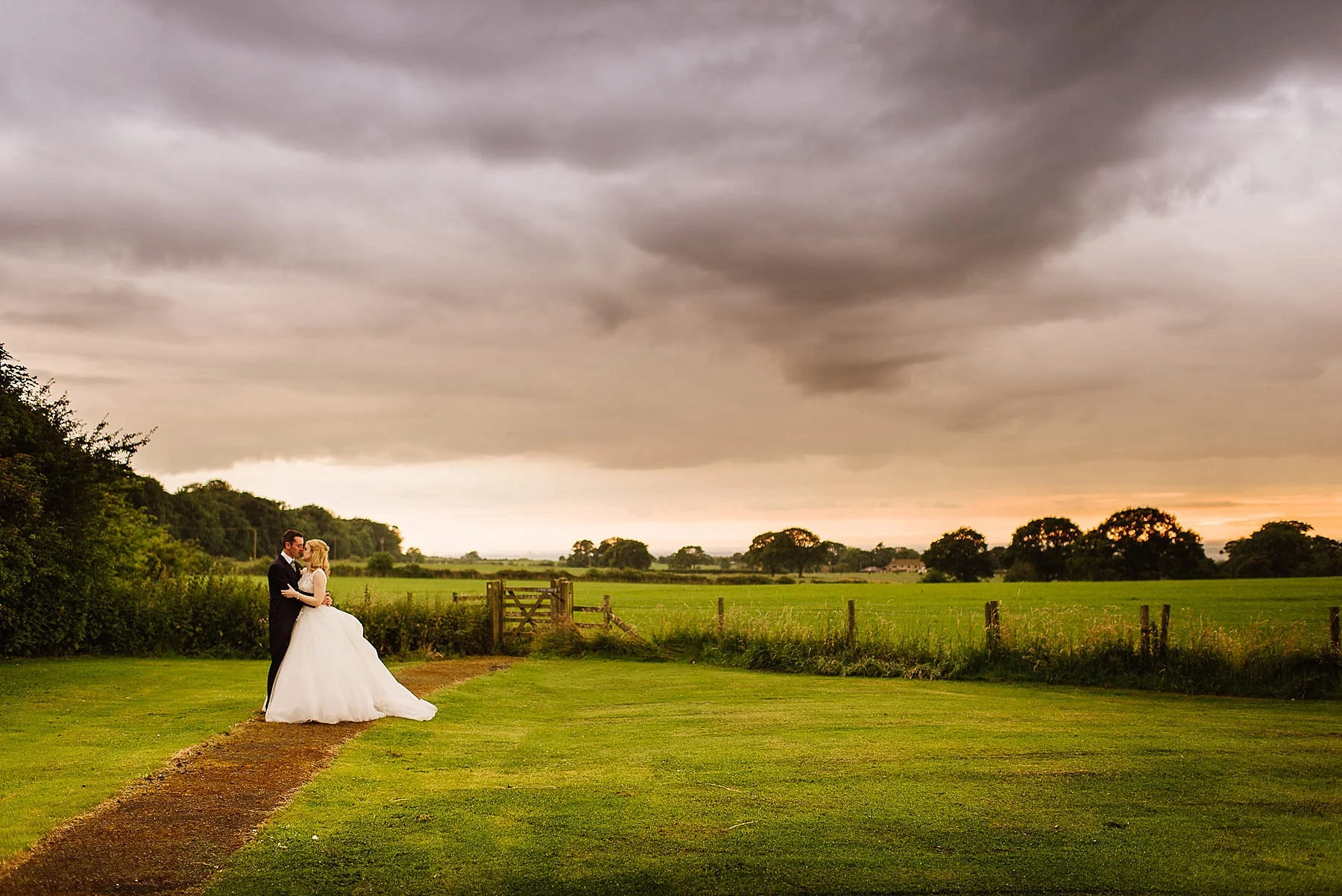 Portrait of the bride and groom at Stanley House with a cloudy sunset