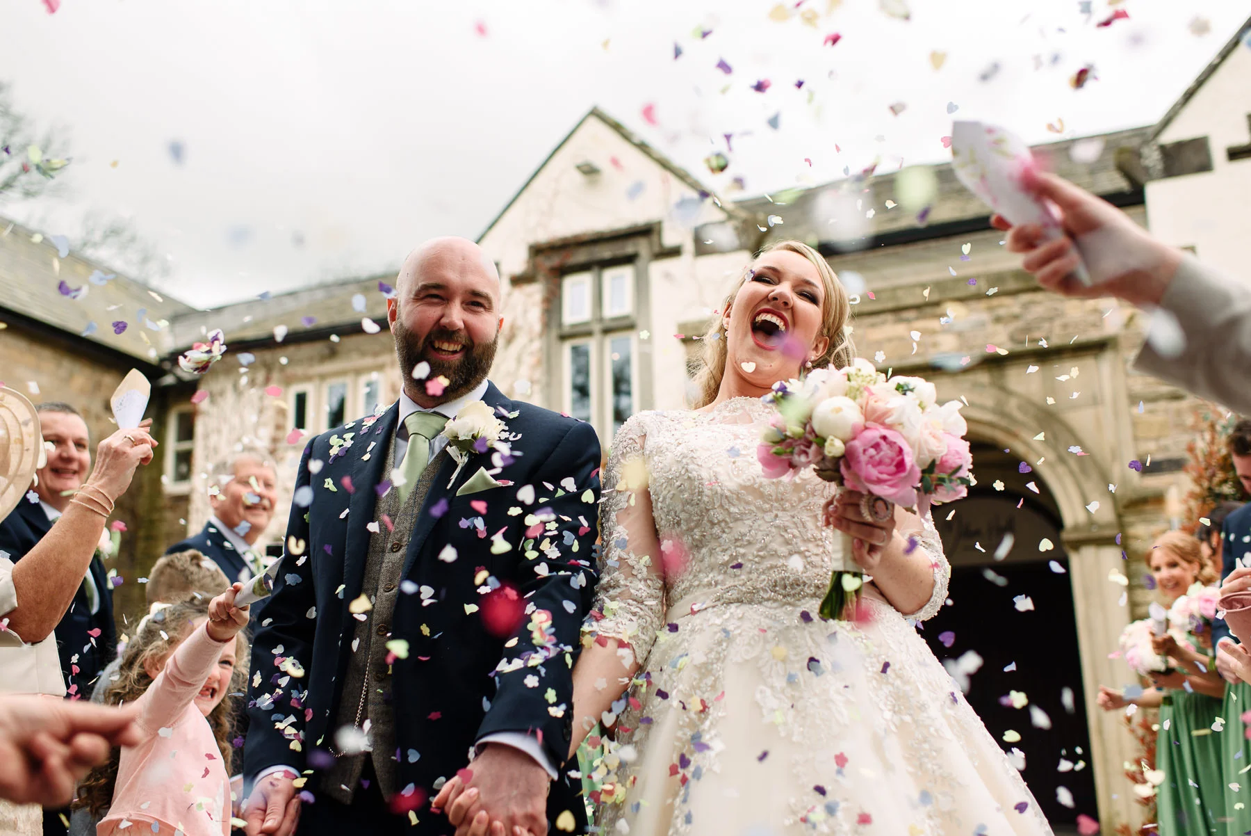 Lauren & Rick outside Mitton Hall, covered in confetti on their Lancashire wedding day