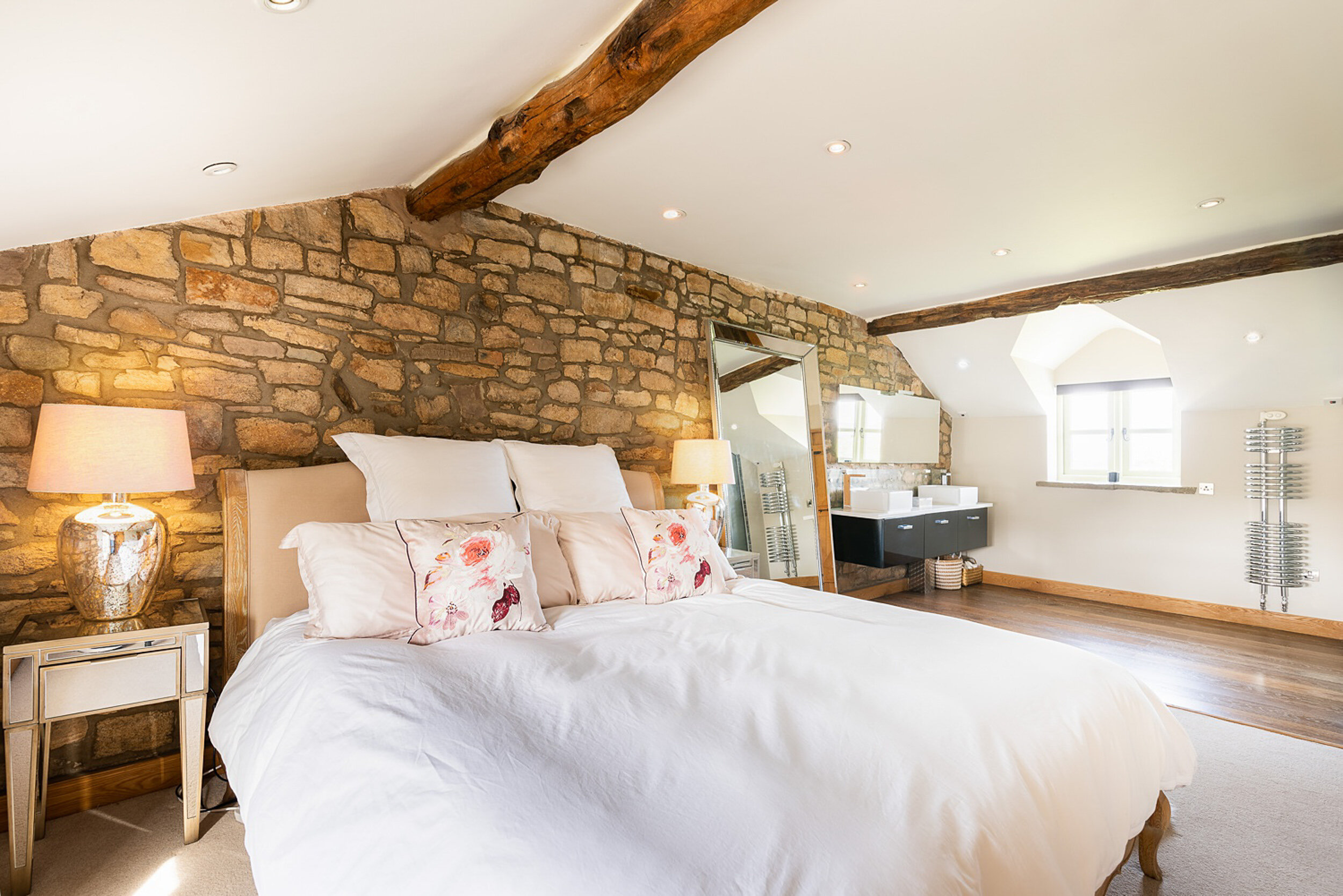 Master bedroom with large queen sized bed and stone wall (Copy)