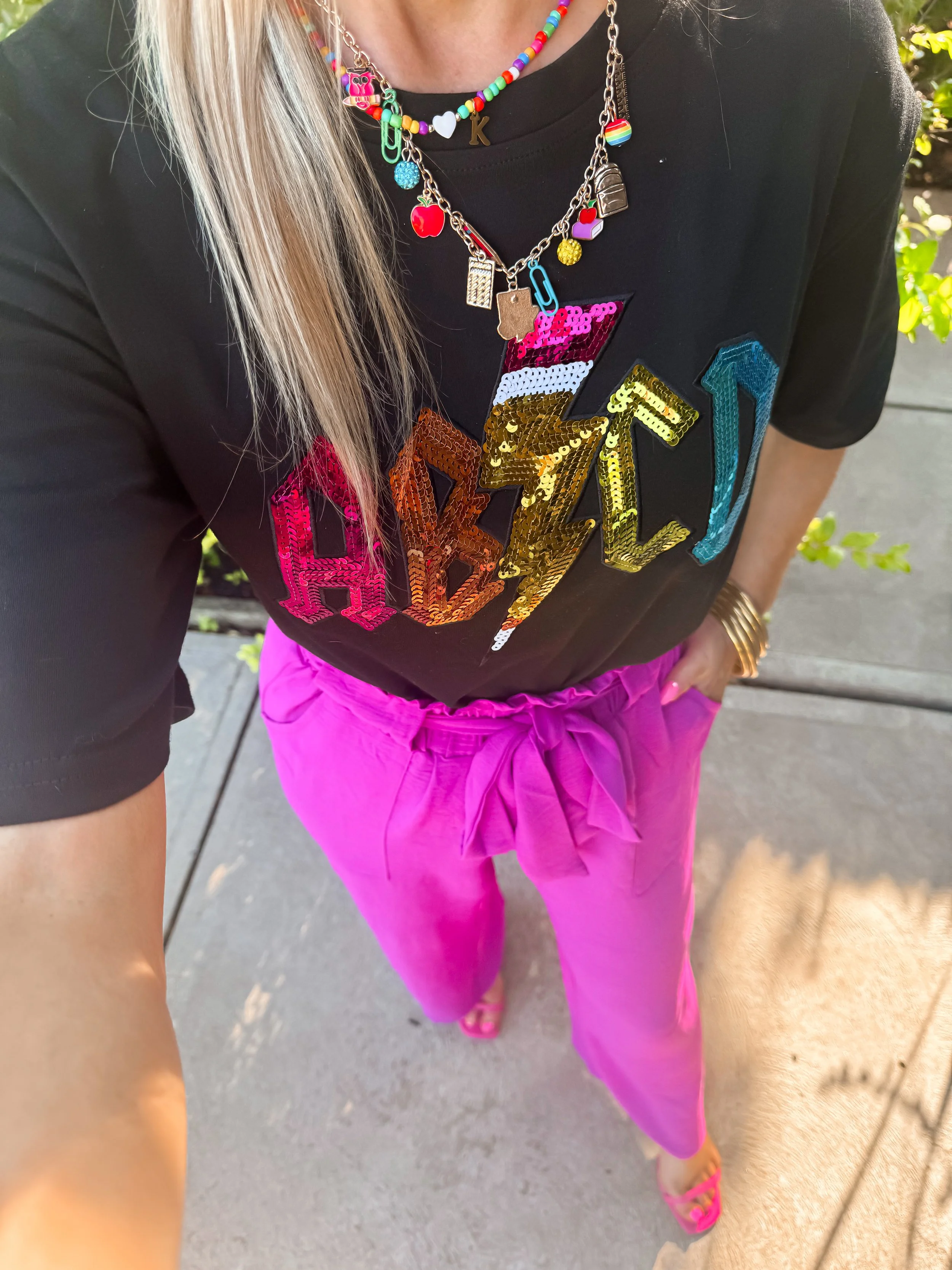  cute teacher outfit with ABCD sequin graphic playing on ACDC with a school themed necklace and colorful pants, Amazon fashion 
