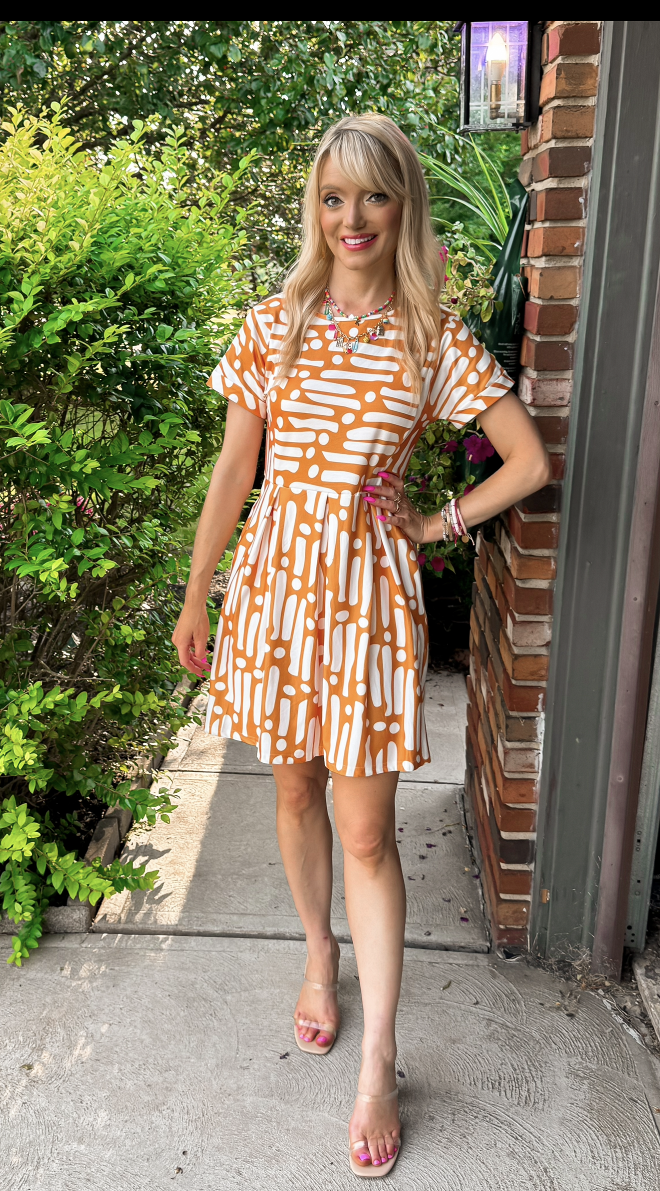  blonde woman wearing a yellow orange abstract print short sleeve dress perfect for business casual, teacher outfit, teacher style, or everyday 