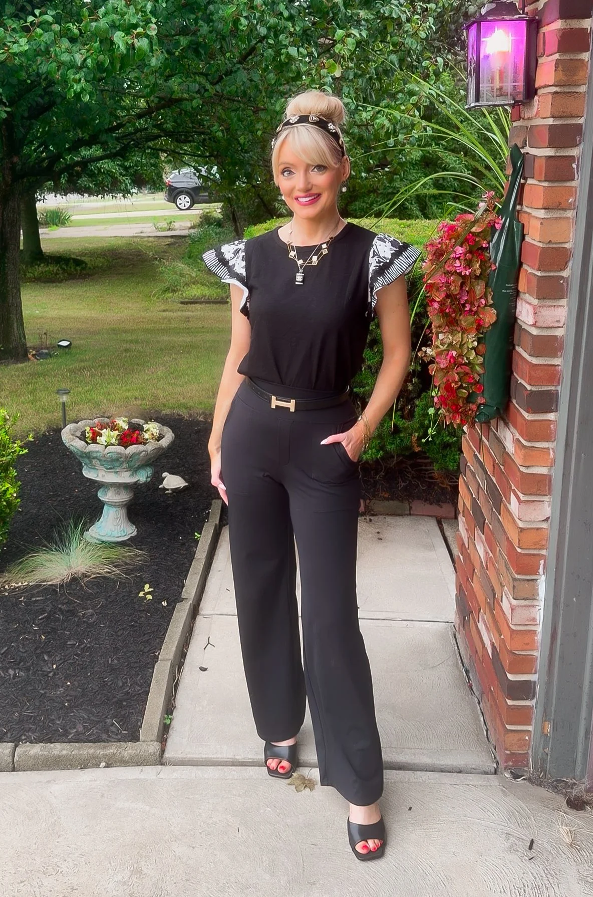  blonde woman wearing black statement short sleeve boutique style top and pull on dress pants for a business casual or teacher style look from Amazon  