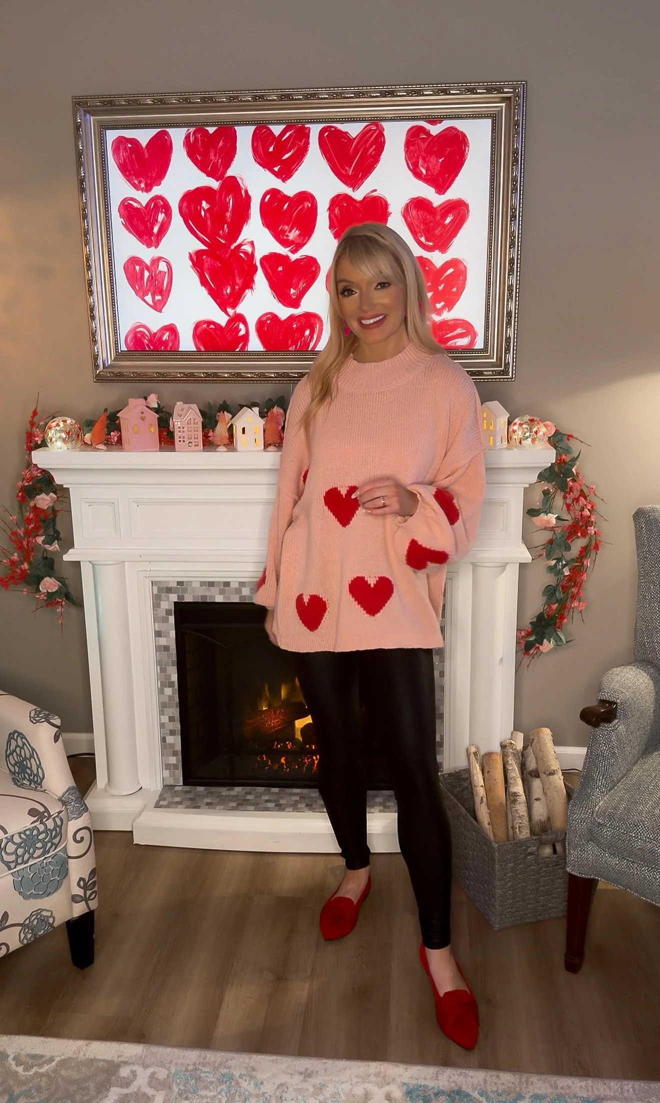Woman with blonde hair wearing oversized heart print sweater from Amazon for a winter Valentine's Day outfit