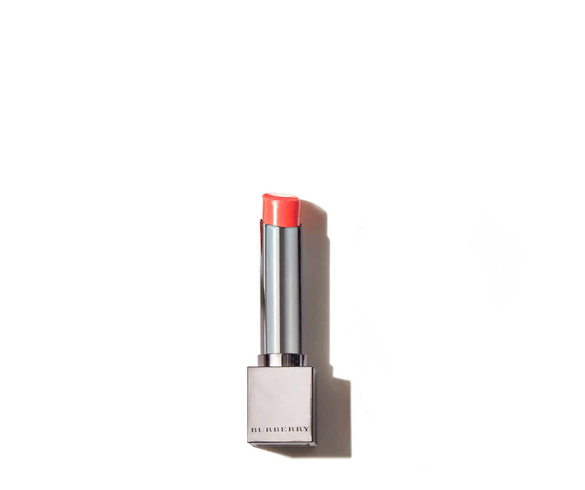 A tube of Burberry lipstick with a pink shade, placed on a white background casting a shadow.