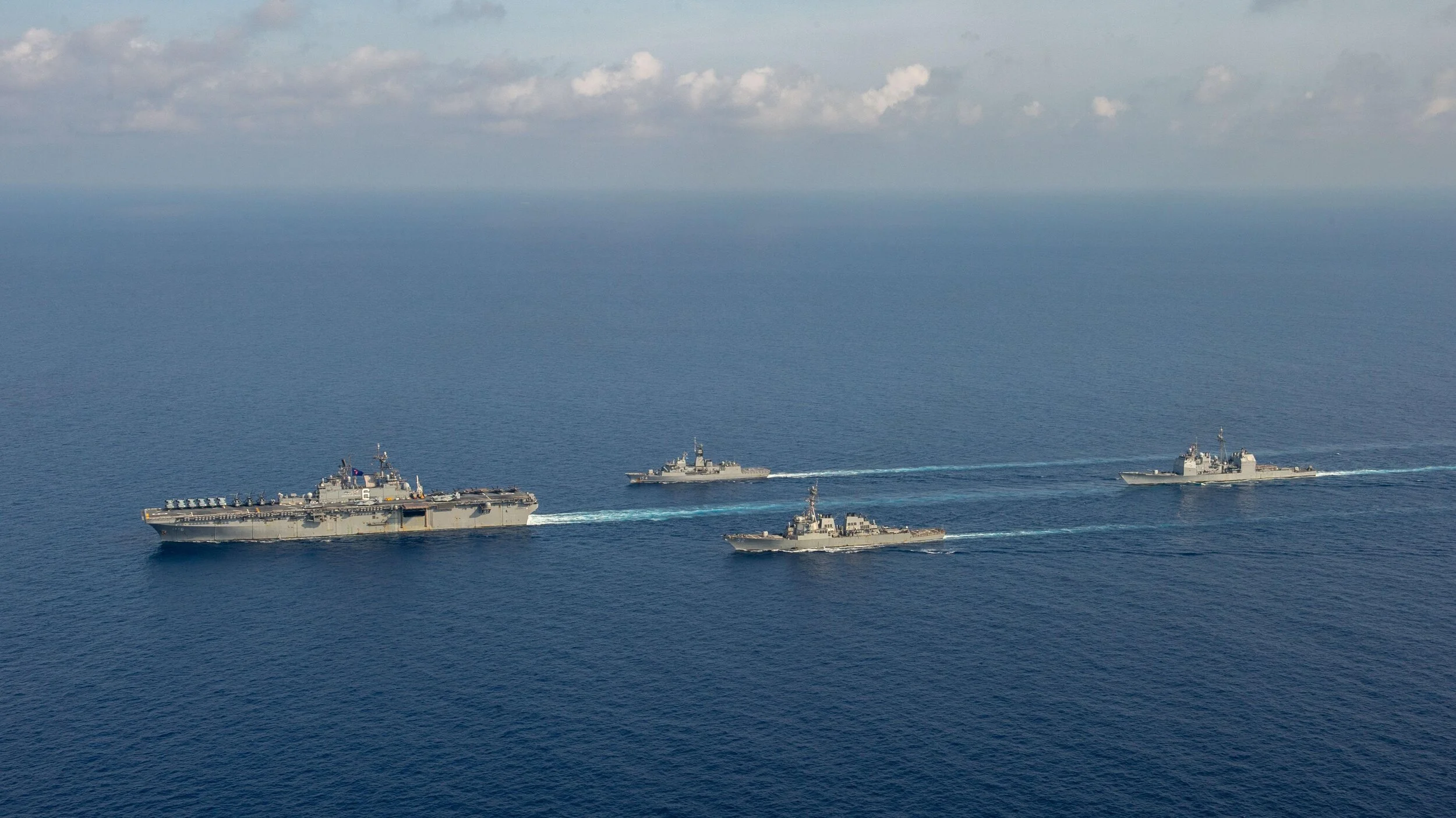 The U.S. Navy amphibious assault ship USS America (LHA 6), left, is underway with the Royal Australian Navy guided-missile frigate HMAS Parramatta (FFH 154), the Arleigh-Burke class guided-missile destroyer USS Barry (DDG 52) and the Ticonderoga-cla…