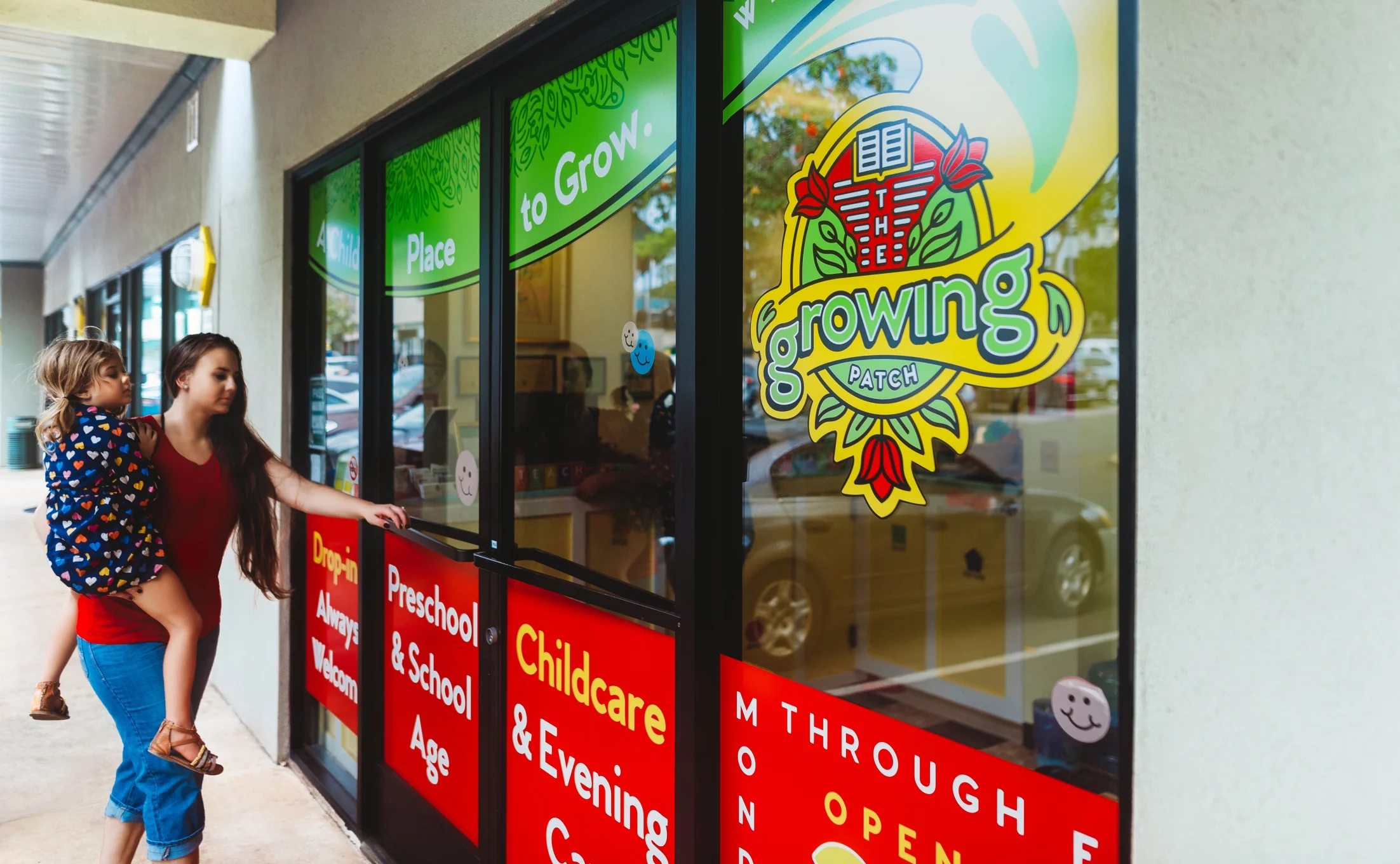 The Growing Patch—Storefront Vinyl Graphics at Rightward Angle with Walking Mother and Daughter