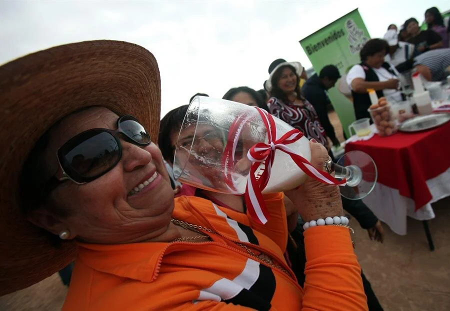 Una mujer prueba un trago de pisco en Perú.jpg