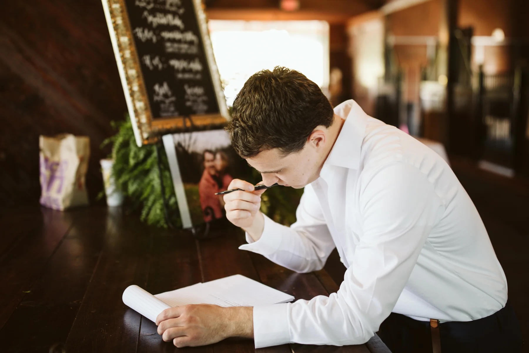 Groom writing out his vows before a stables at strawberry creek wedding in Knoxville, tennessee