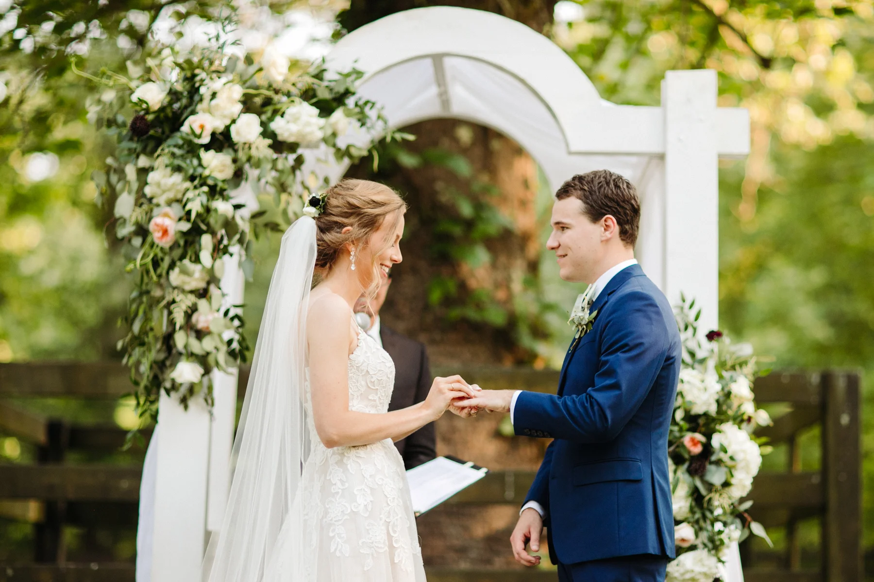 bride puts a ring on her groom's finger at a stables at strawberry creek wedding in knoxville, tennessee