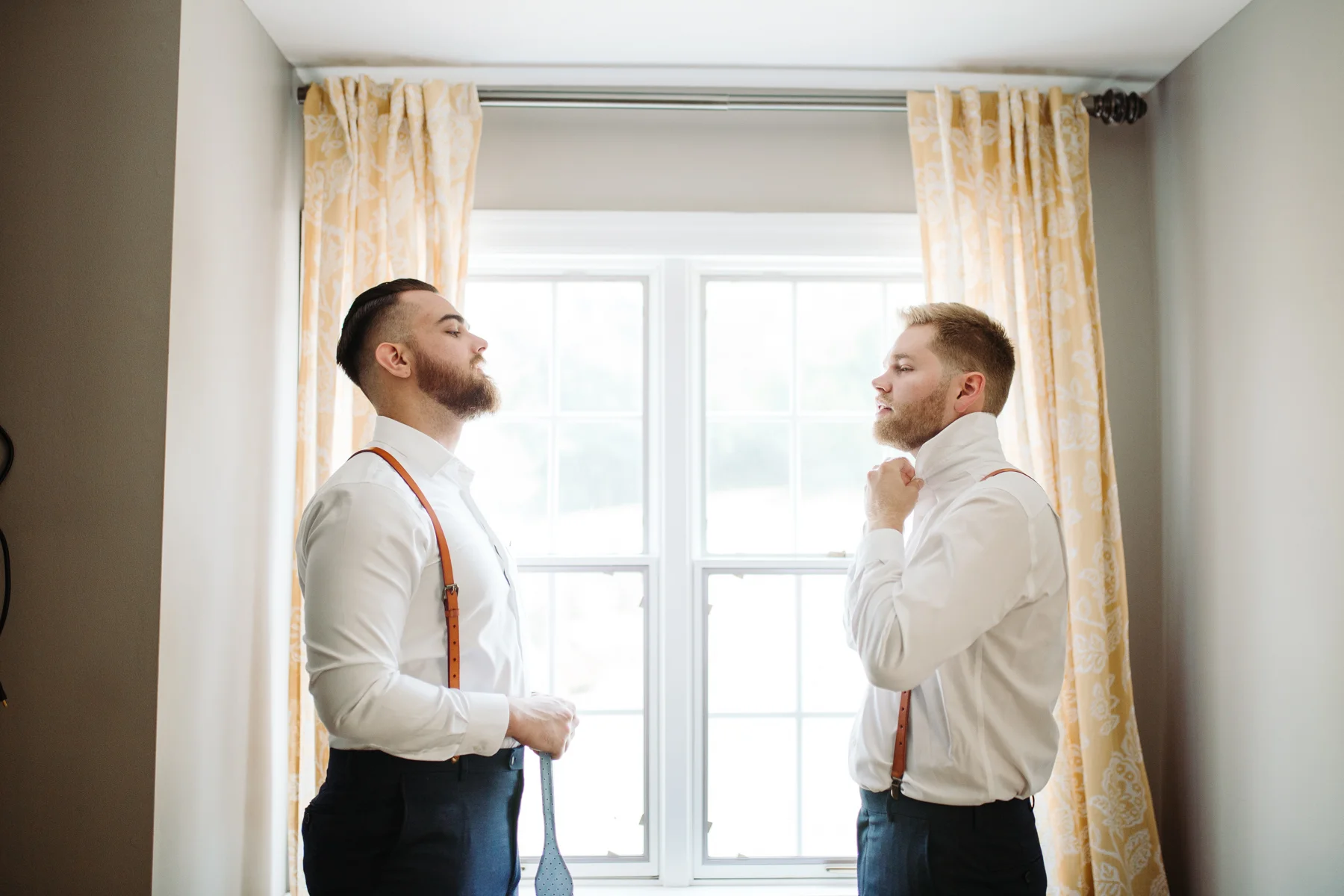 best man helping groom tie his tie at a Sunny summer wedding at Dara's Garden in Knoxville, Tennessee