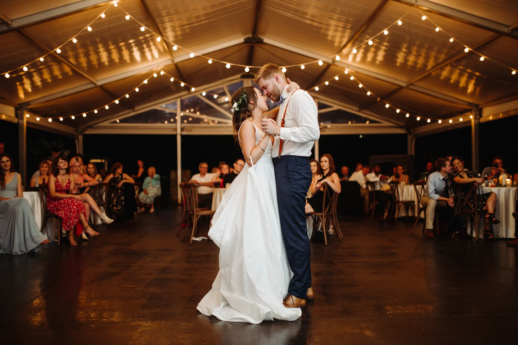 First dance under string lights at a Sunny summer wedding at Dara's Garden in Knoxville, Tennessee