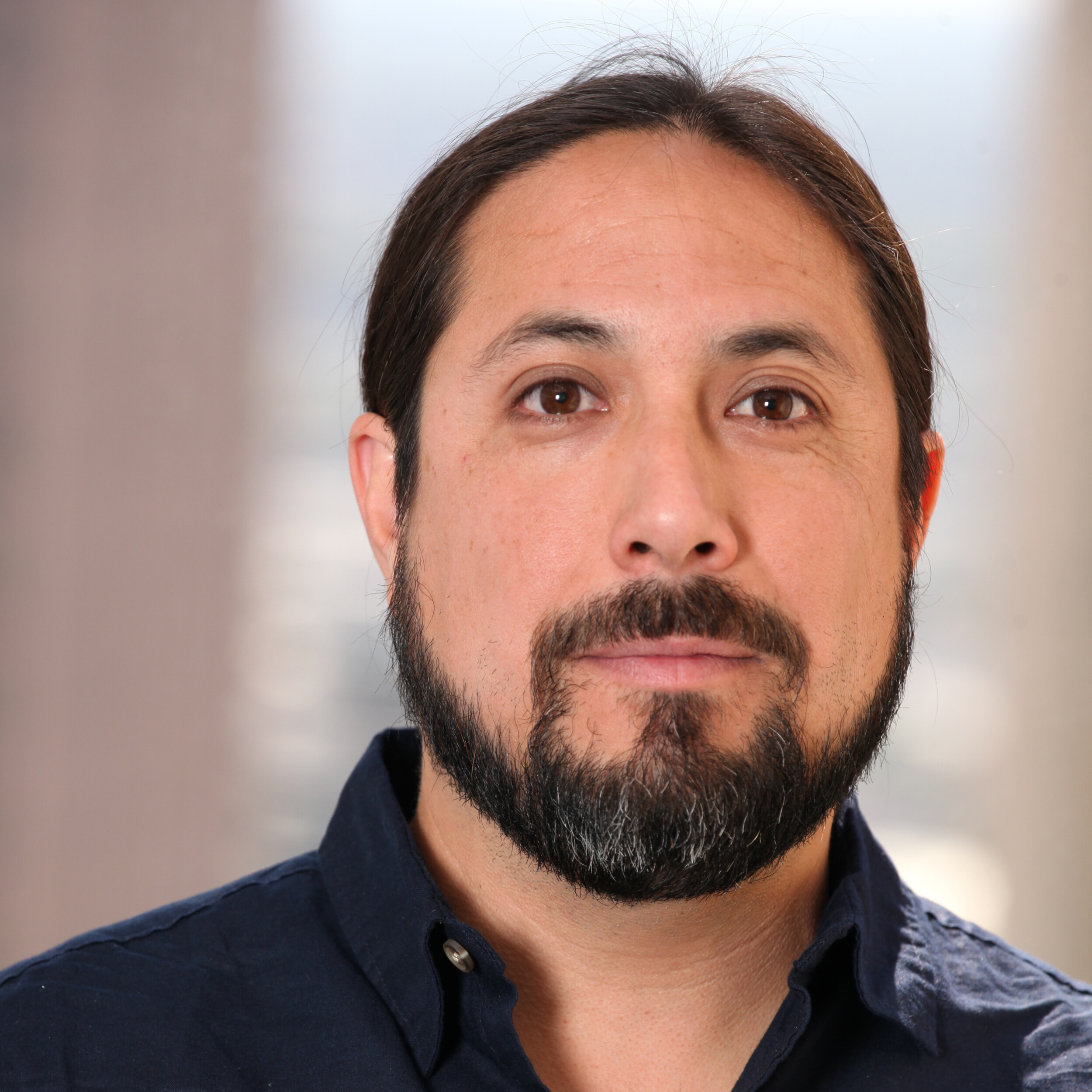 Image of board member Aaron Perez wearing a dark blue dress shirt