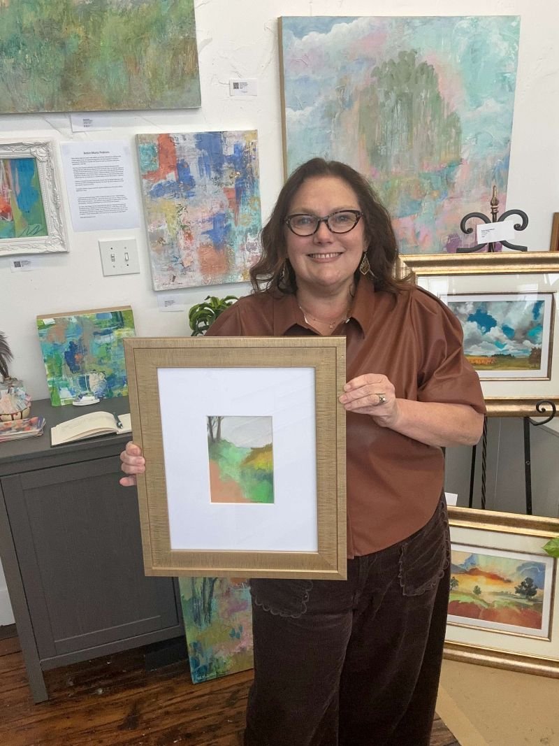 robin holding art in studio nearing destination w.jpg