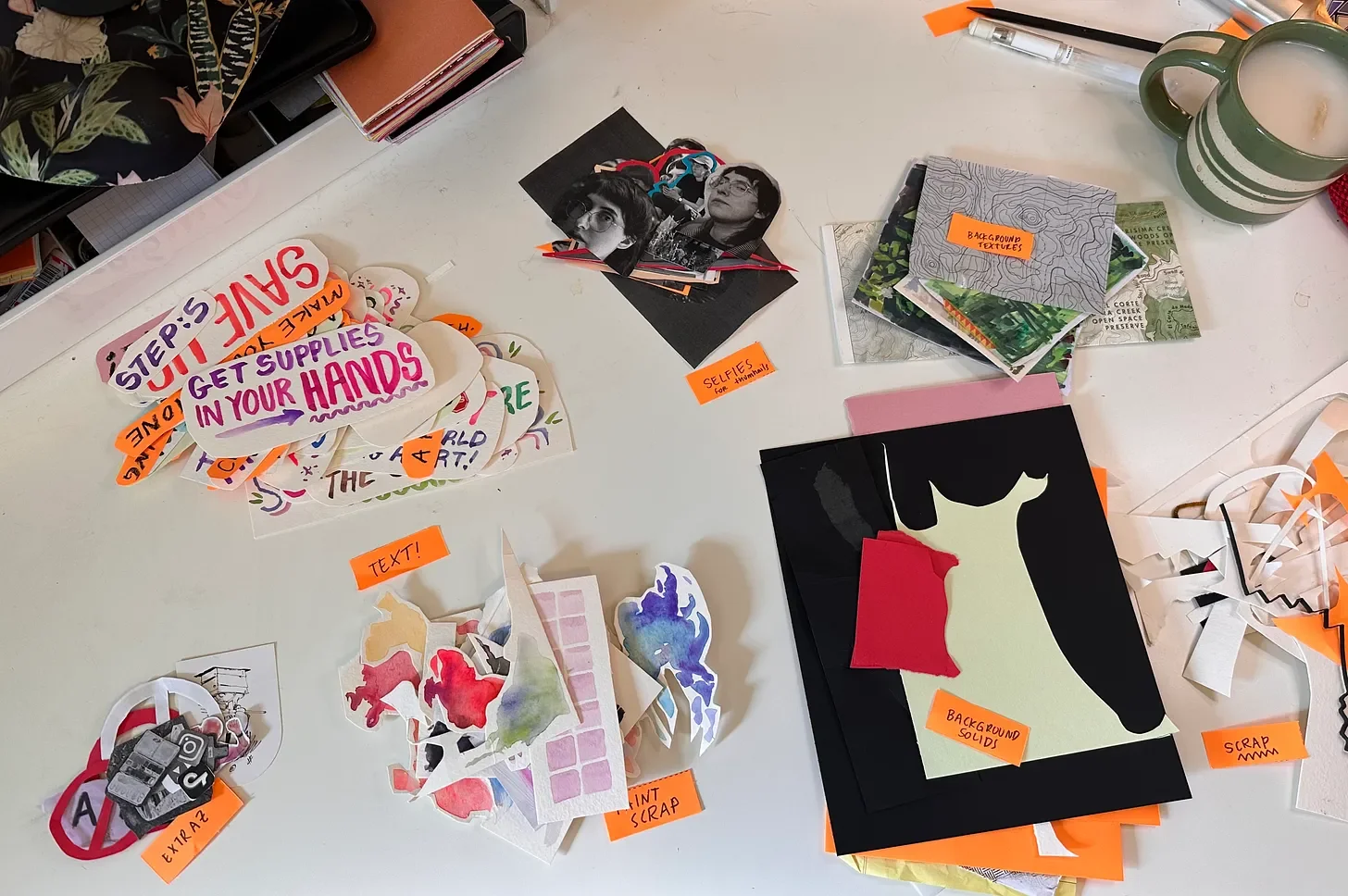 white desk with piles of collaged materials sitting in small piles based on theme