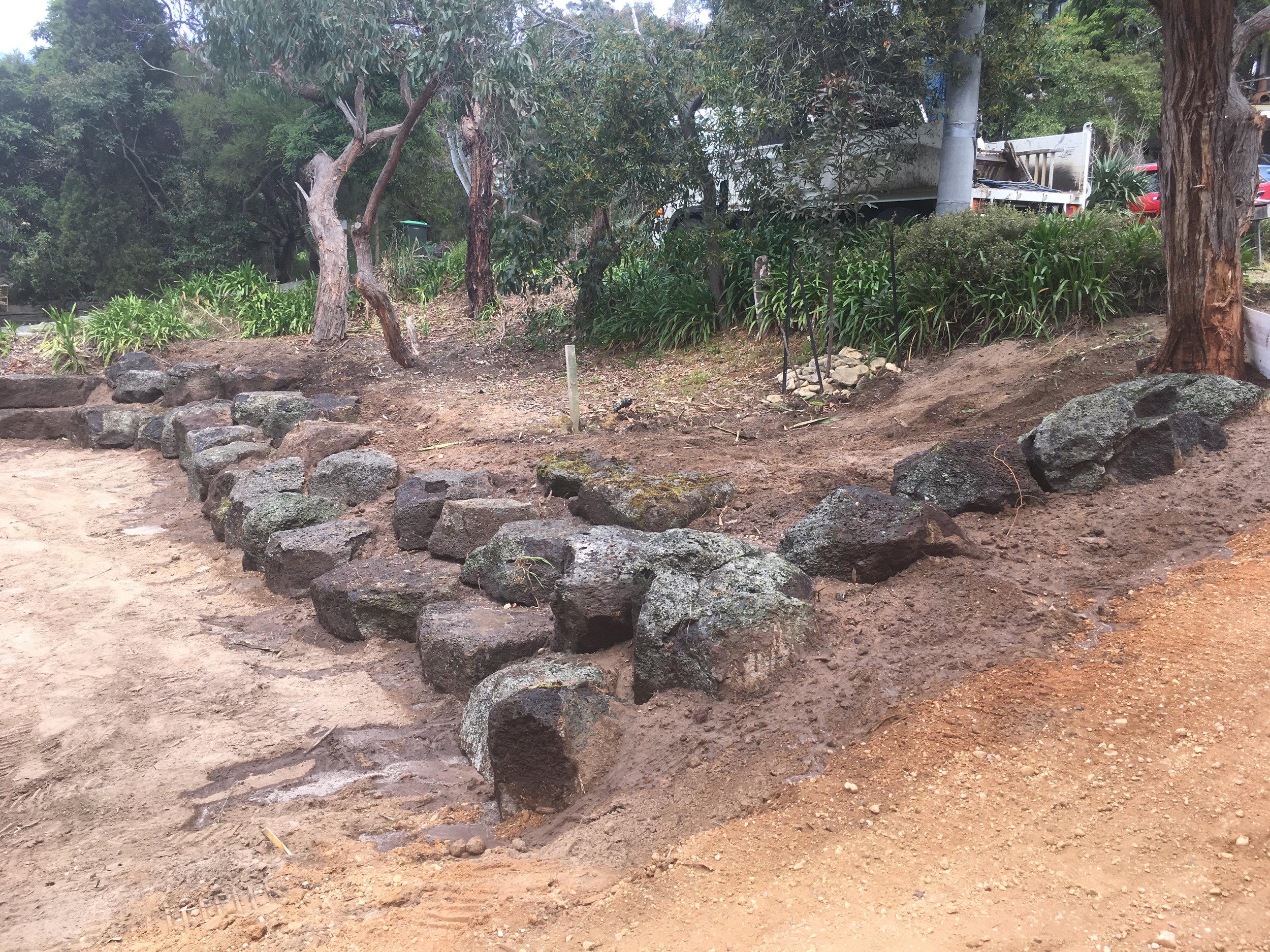 Progress shot installing rock retaining wall