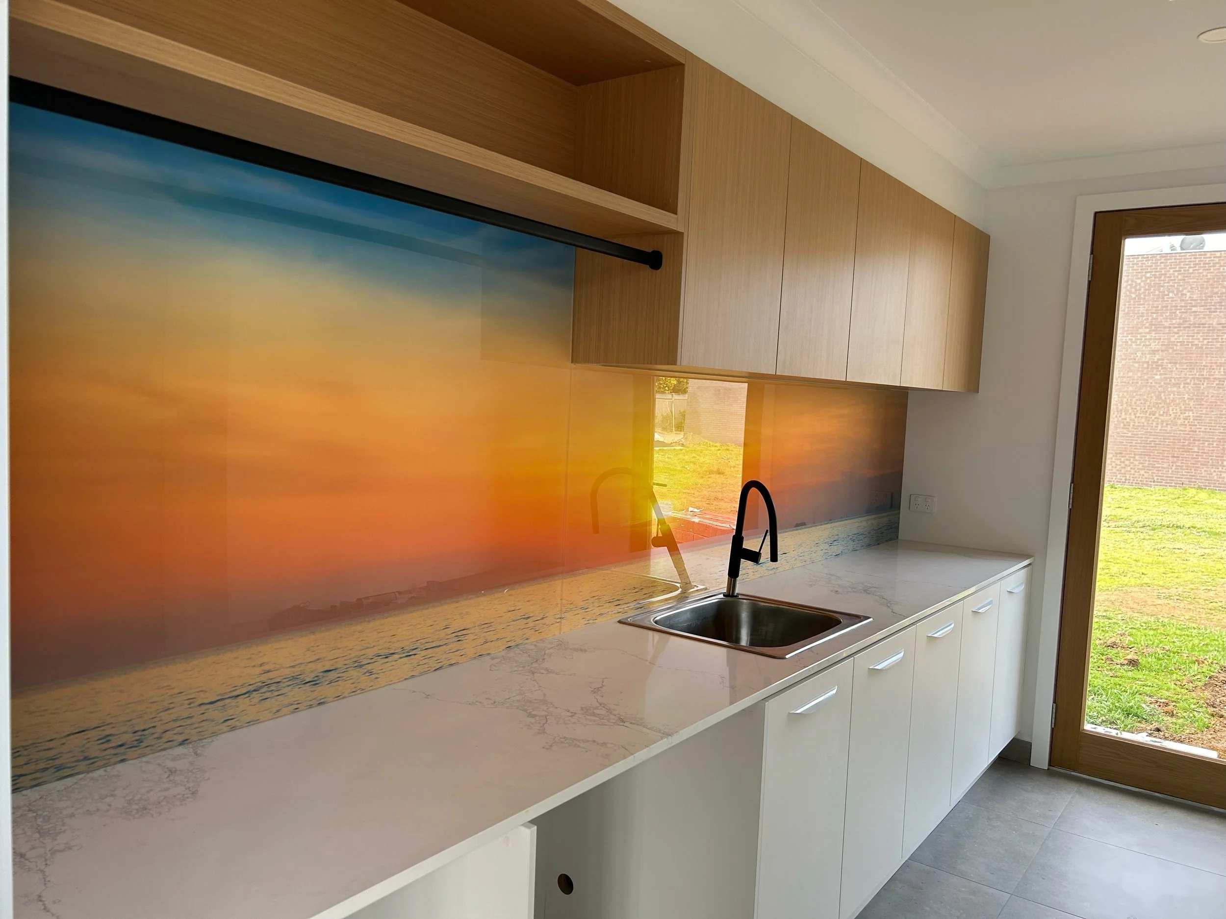 Sunset and water printed laundry splashback