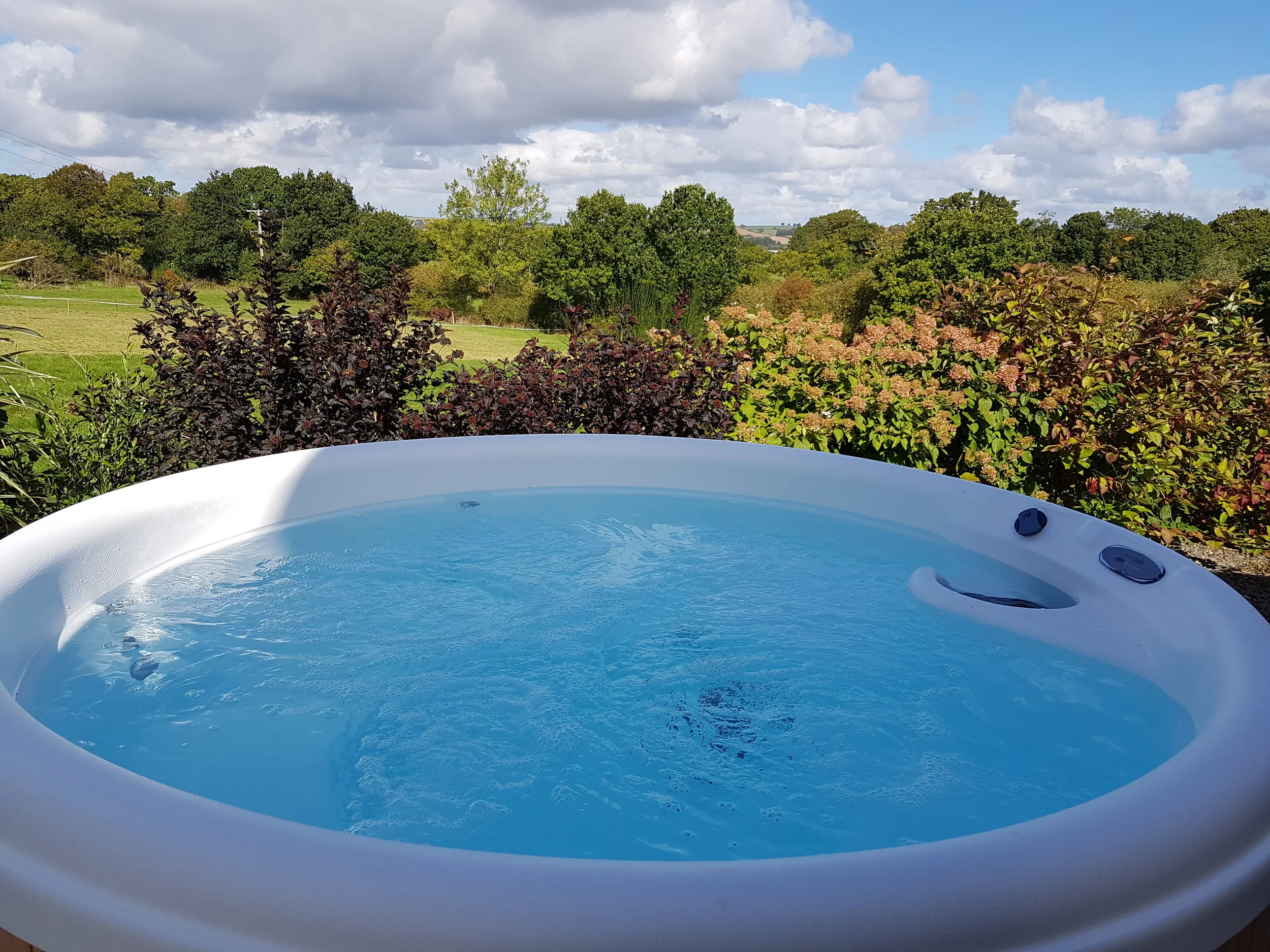 The hot tub is next to the Retreat, overlooking beautiful countryside.