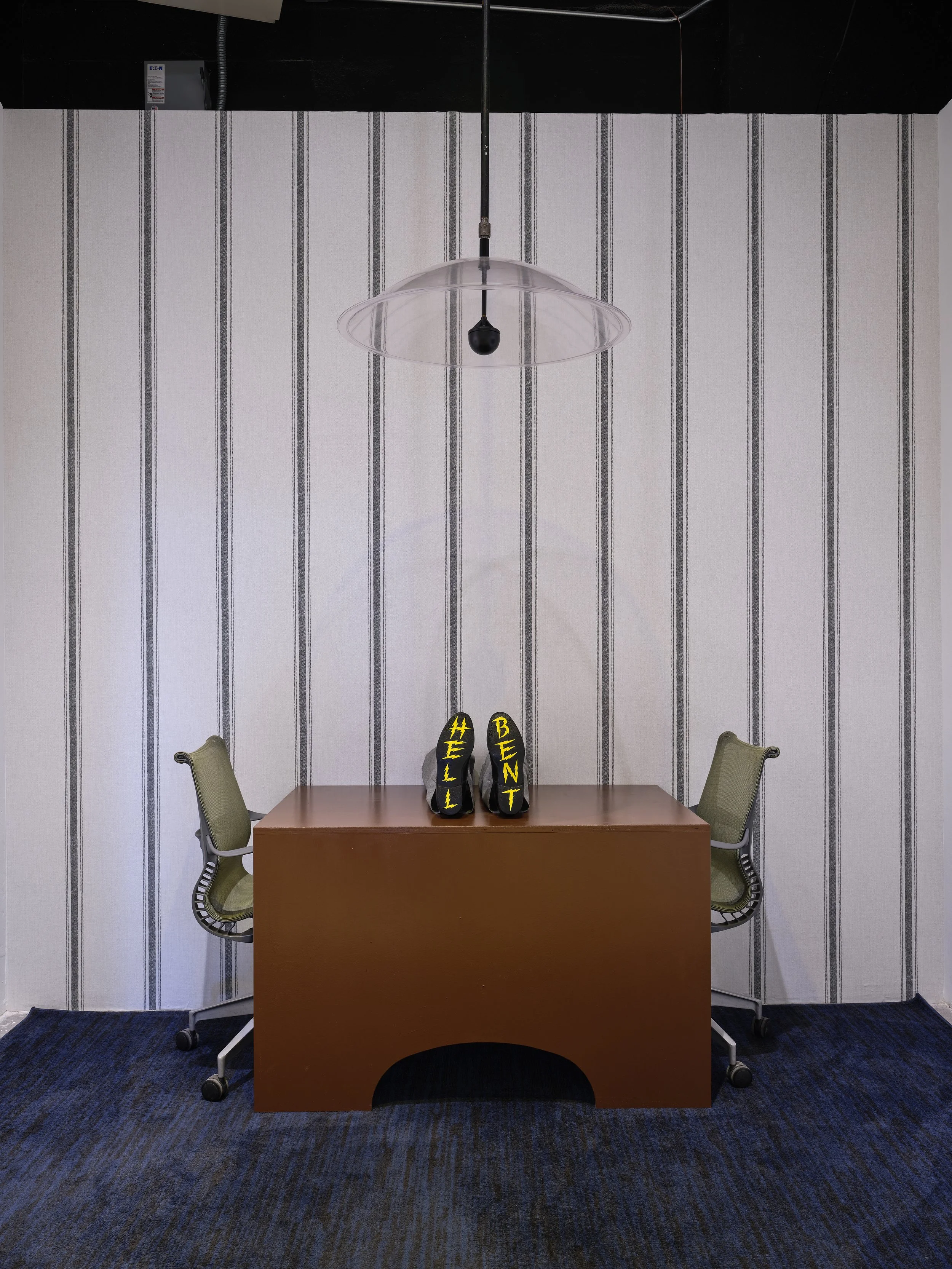  Lindsey White, Hell Bent, 2025, wood, enamel paint, shoes, desk chairs, audio 