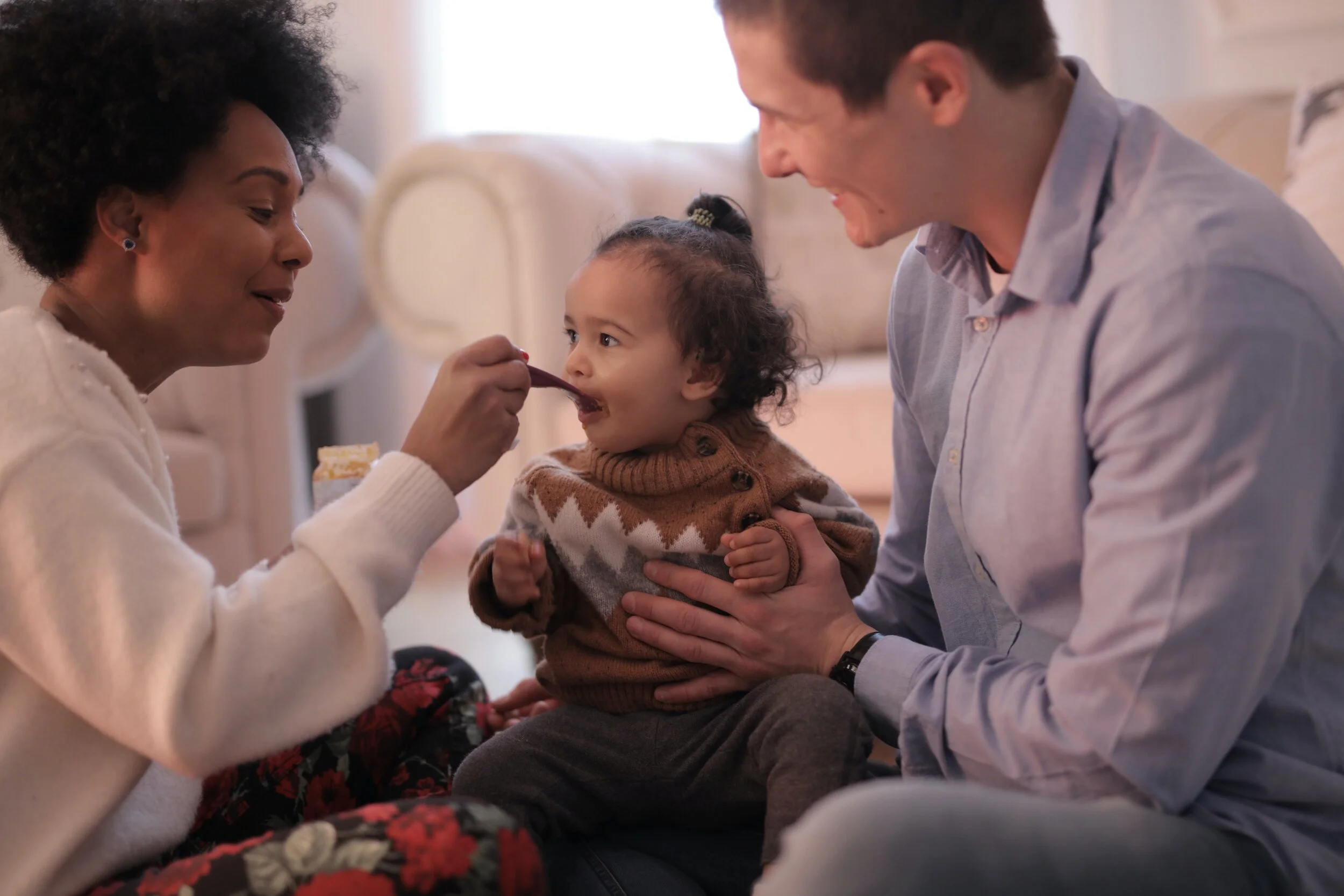 Mom and dad feeding their toddler