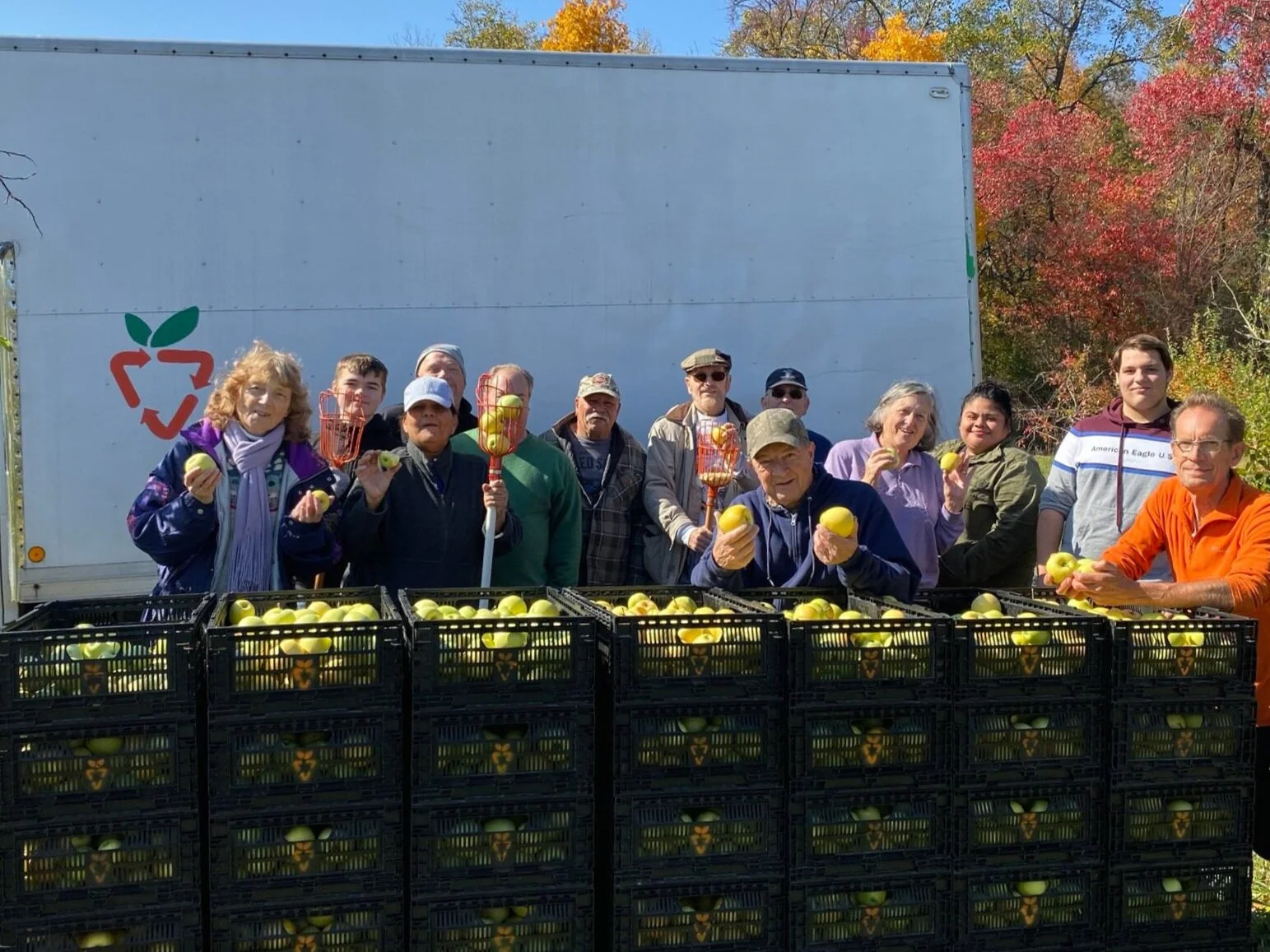 Group of people holding gleaned apples
