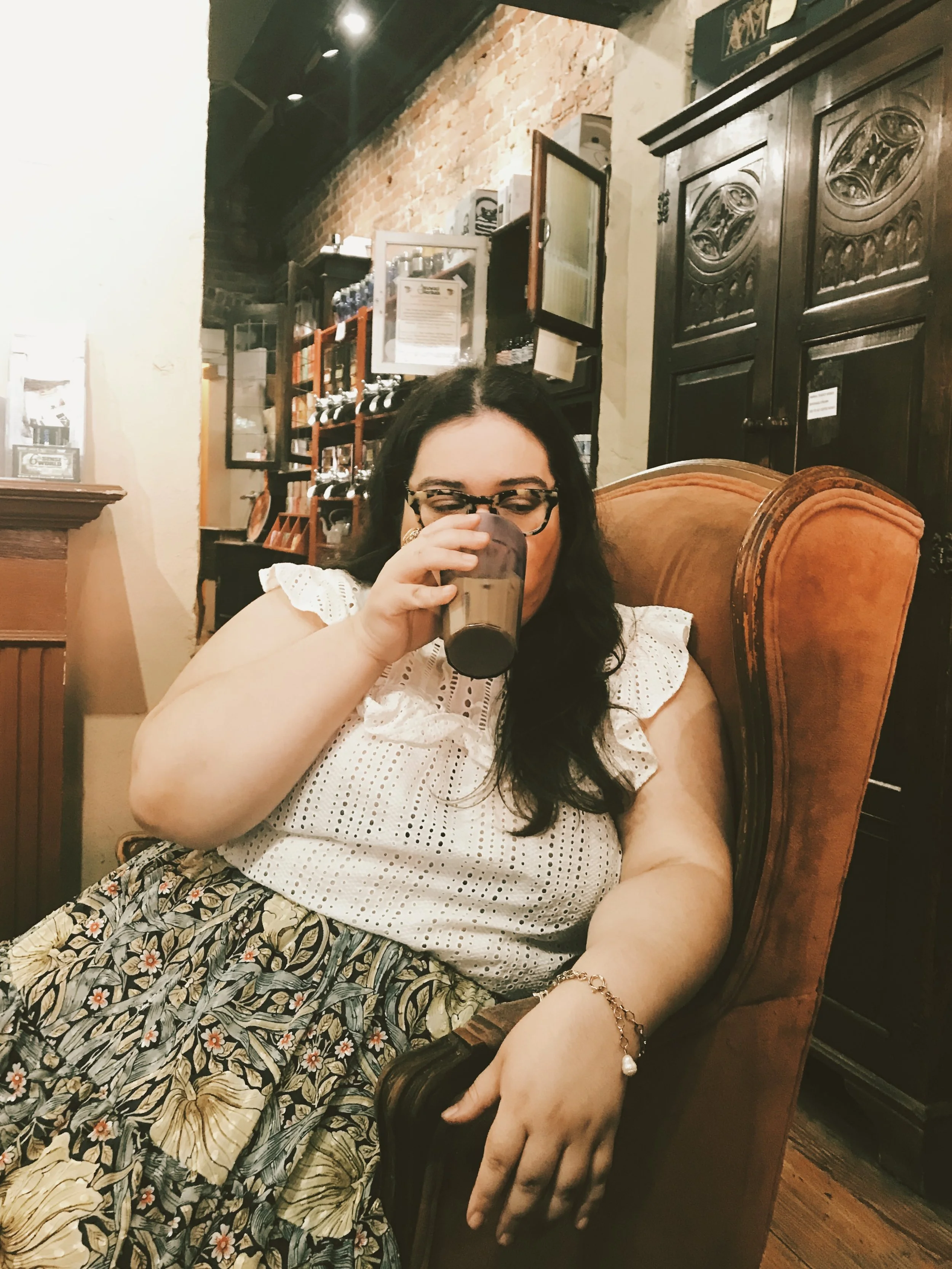 The author, with her favorite drink, in one of her favorite chairs.