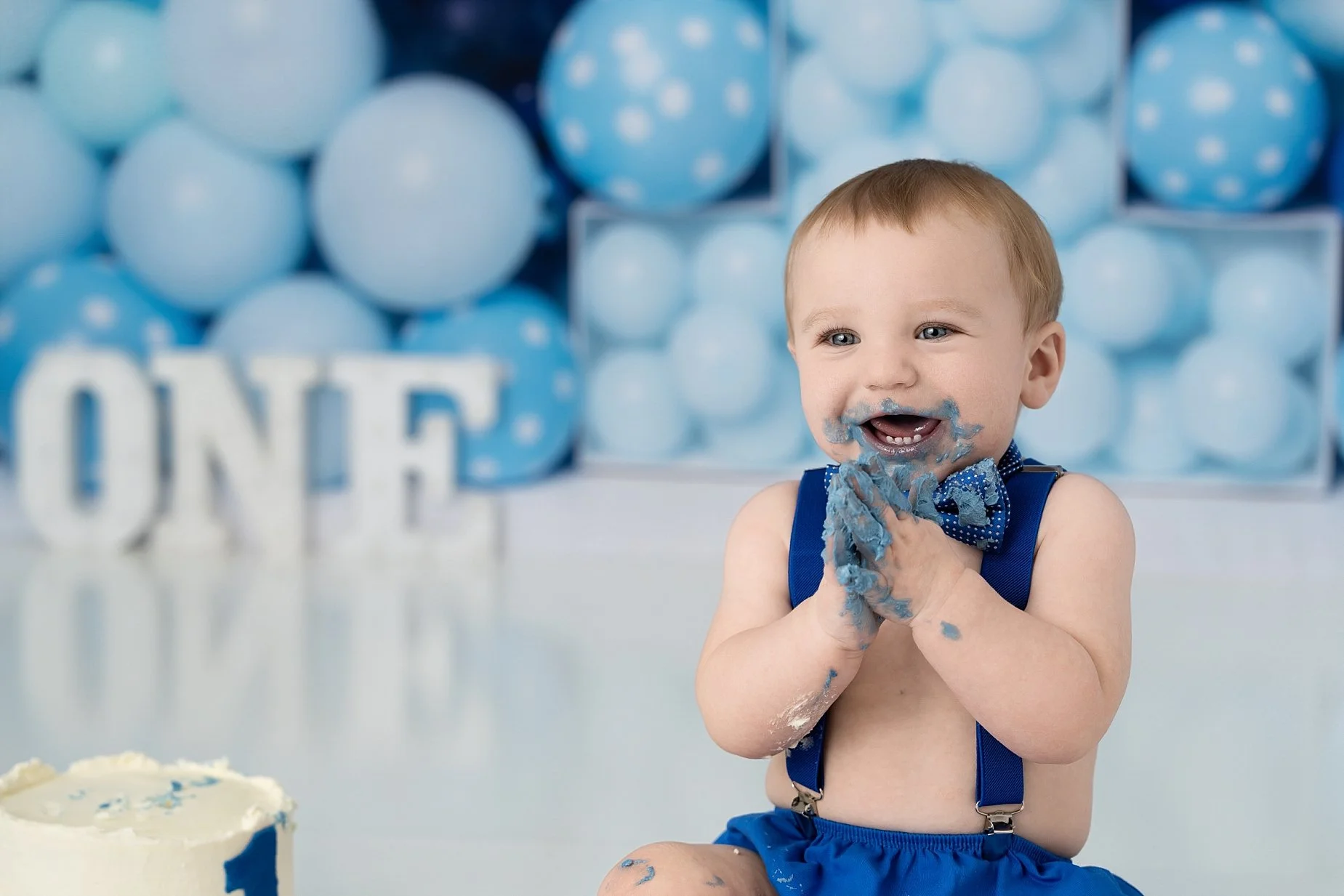 Baby boy cake smash session with blue frosting messy hands first birthday Glen Carbon IL.