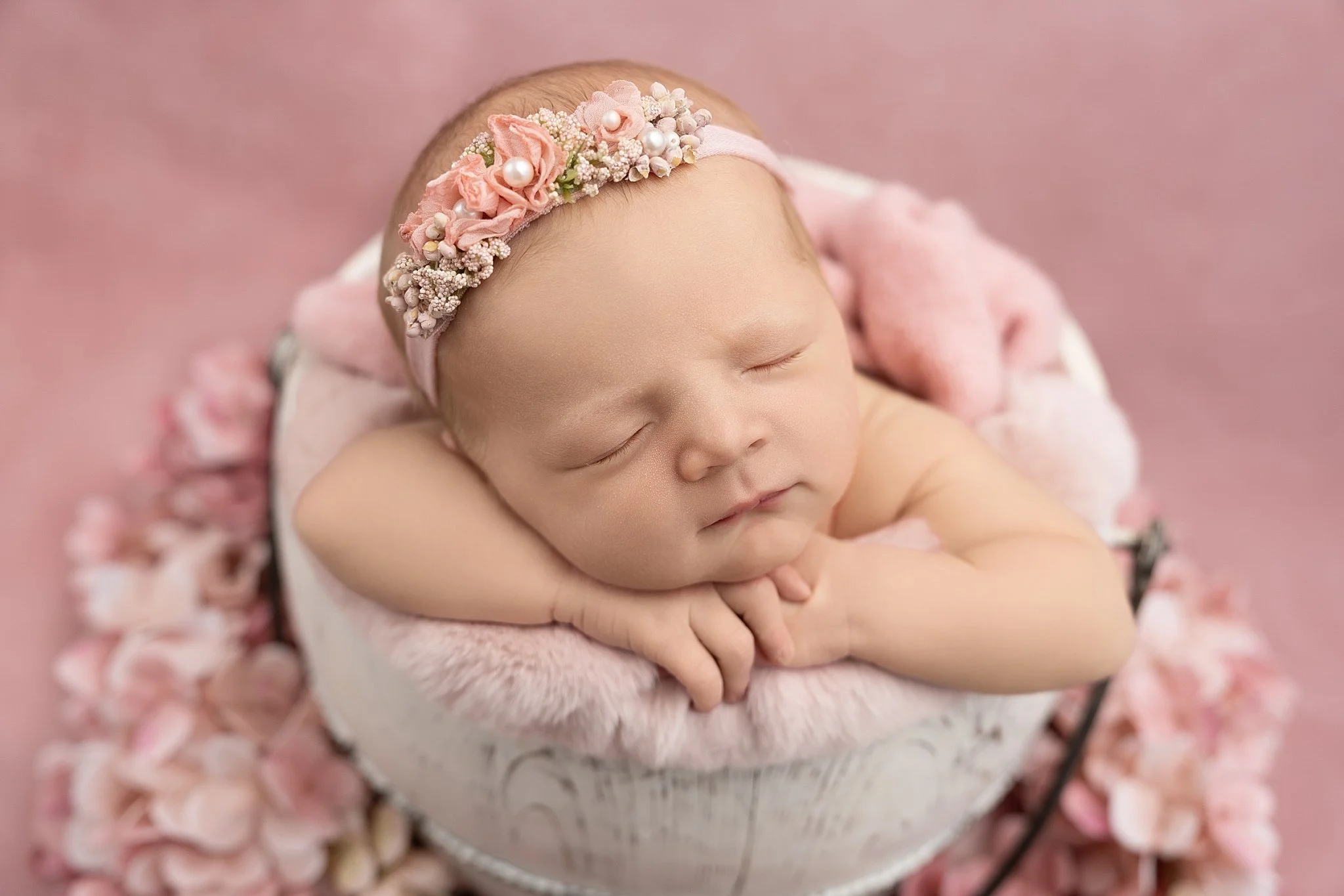 Newborn girl studio photography with pink backdrop and floral headband in Glen Carbon, Illinois
