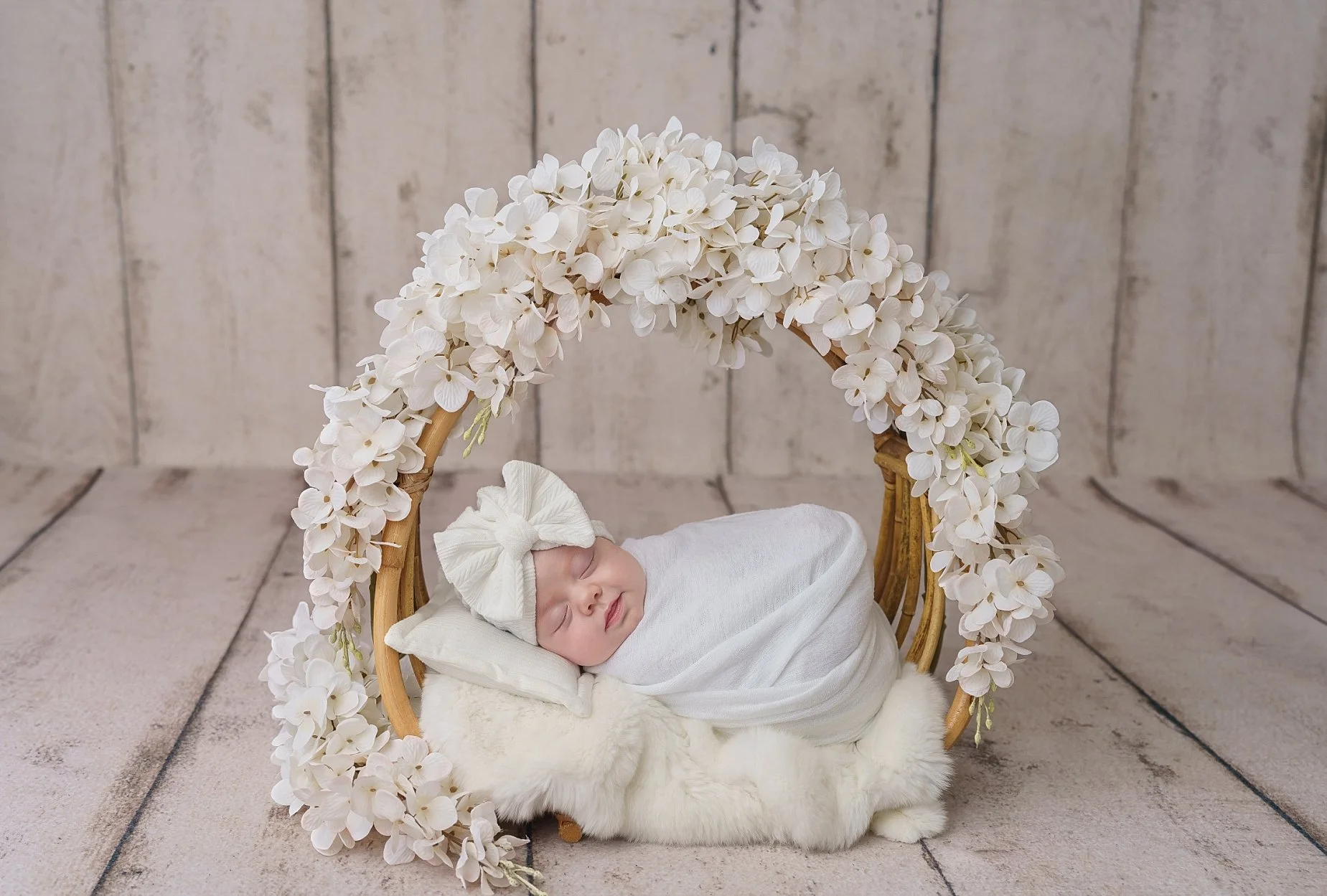 Newborn baby girl sleeping under a white floral ring setup photographed in a Glen Carbon Illinois newborn photography studio.
