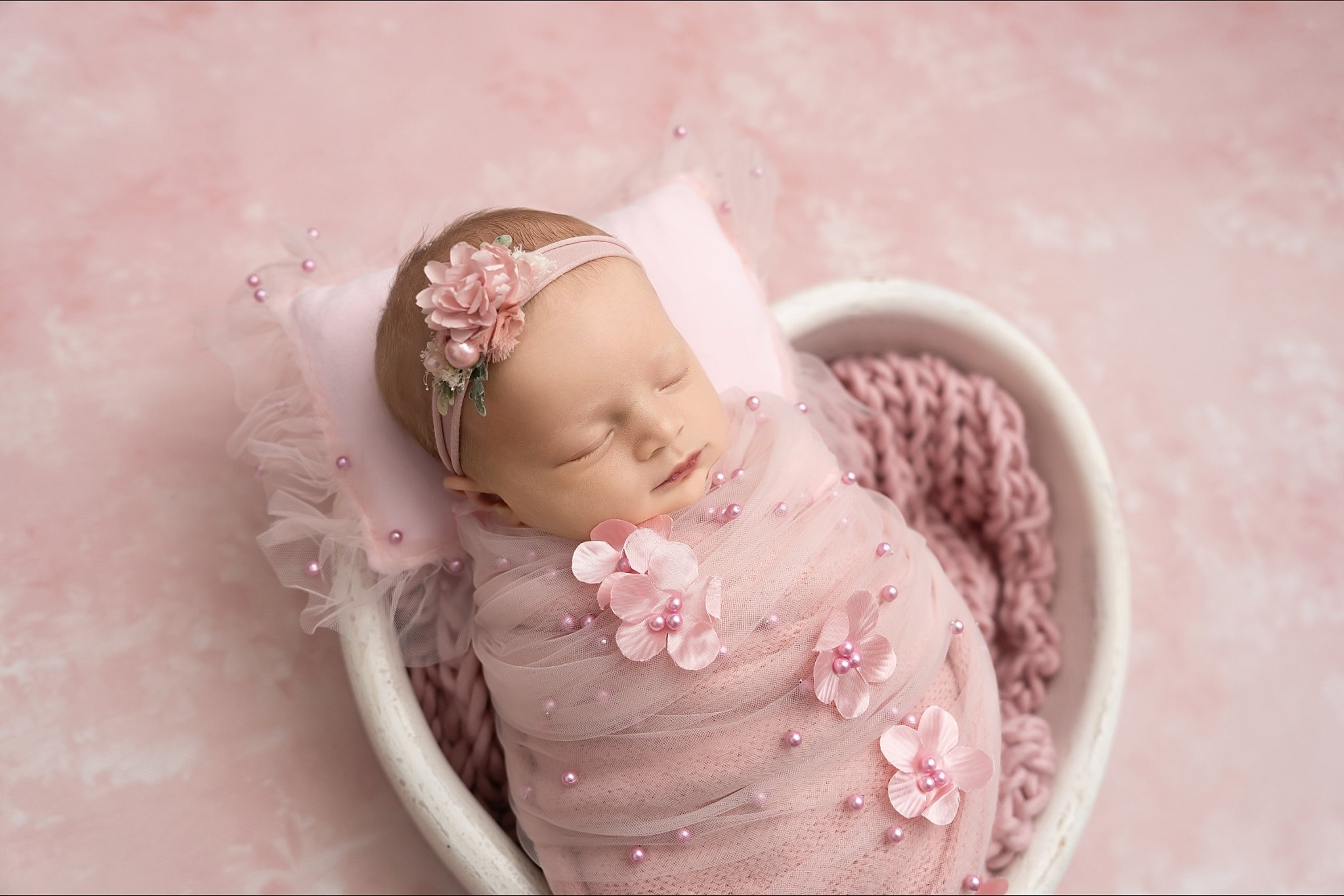 Studio newborn girl photography with pink wrap and floral details in Glen Carbon, Illinois