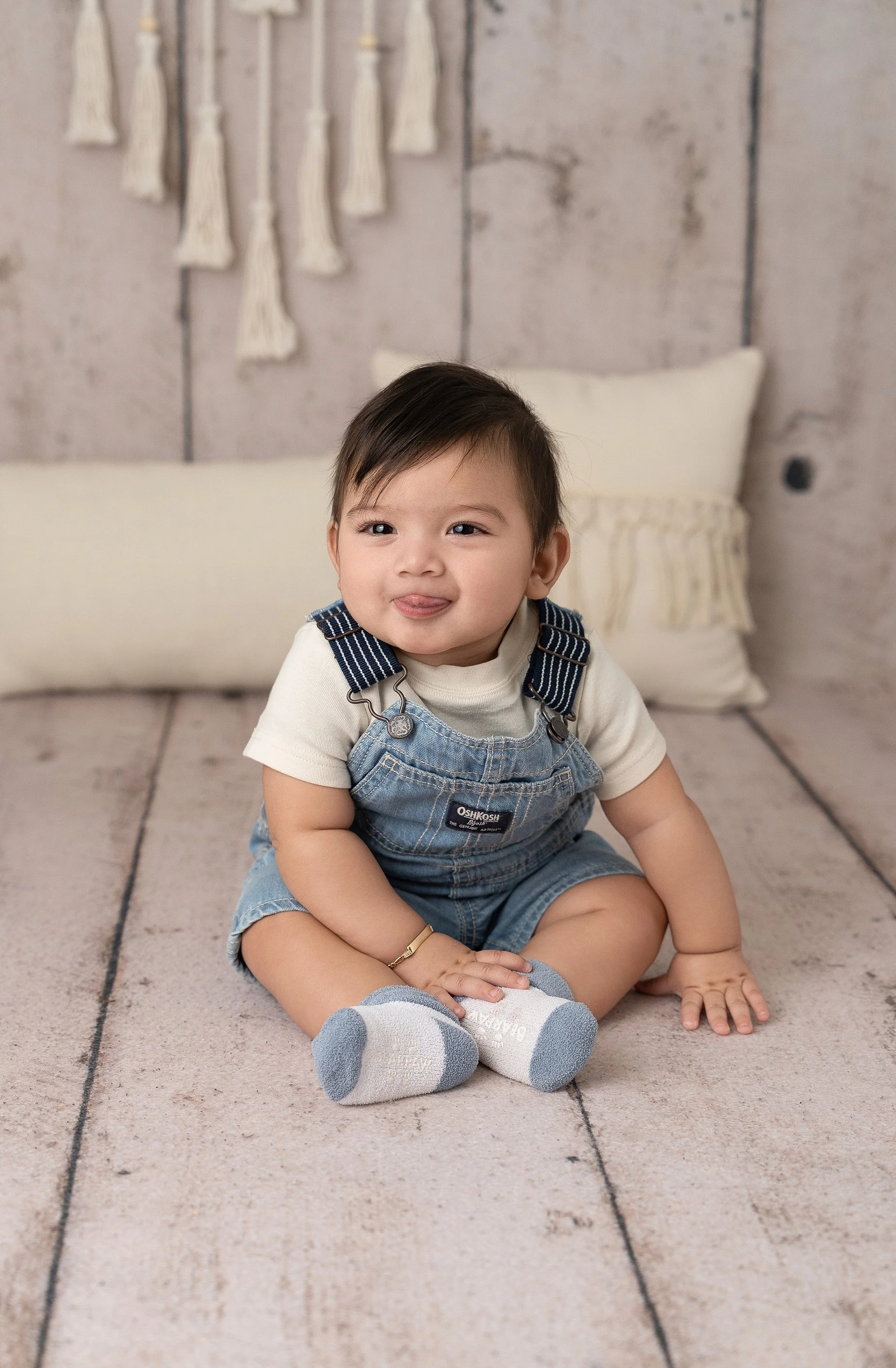 6 month baby sitting milestone session in Edwardsville Illinois studio with neutral backdrop and denim outfit.