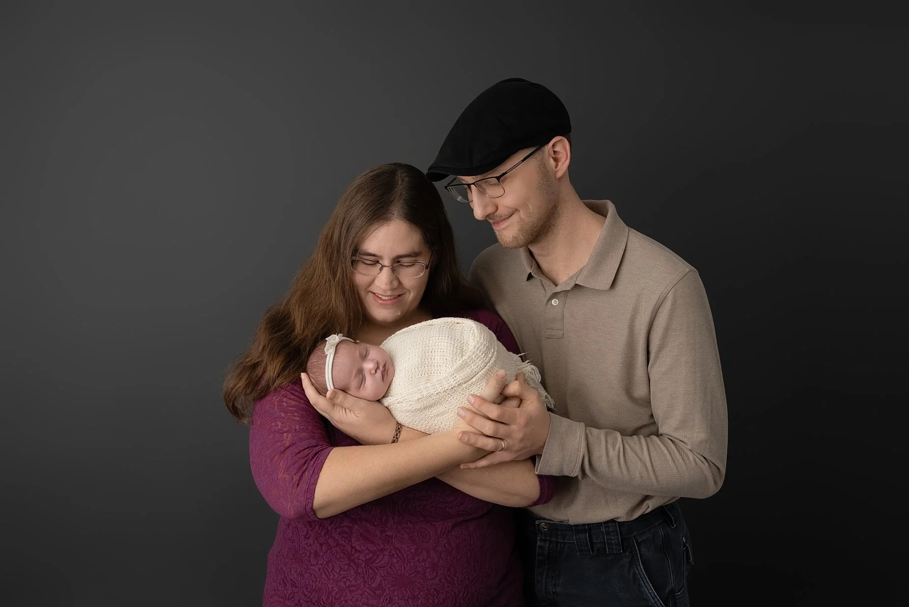 Parents holding their newborn baby during a studio family portrait session photographed by Conner James Photography in Glen Carbon Illinois.