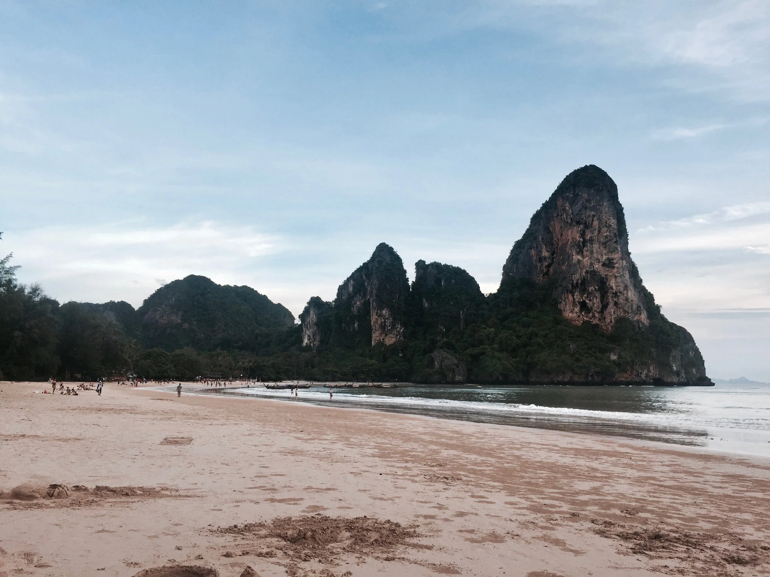 boats in railay, thailand on a summer day with a travel blog