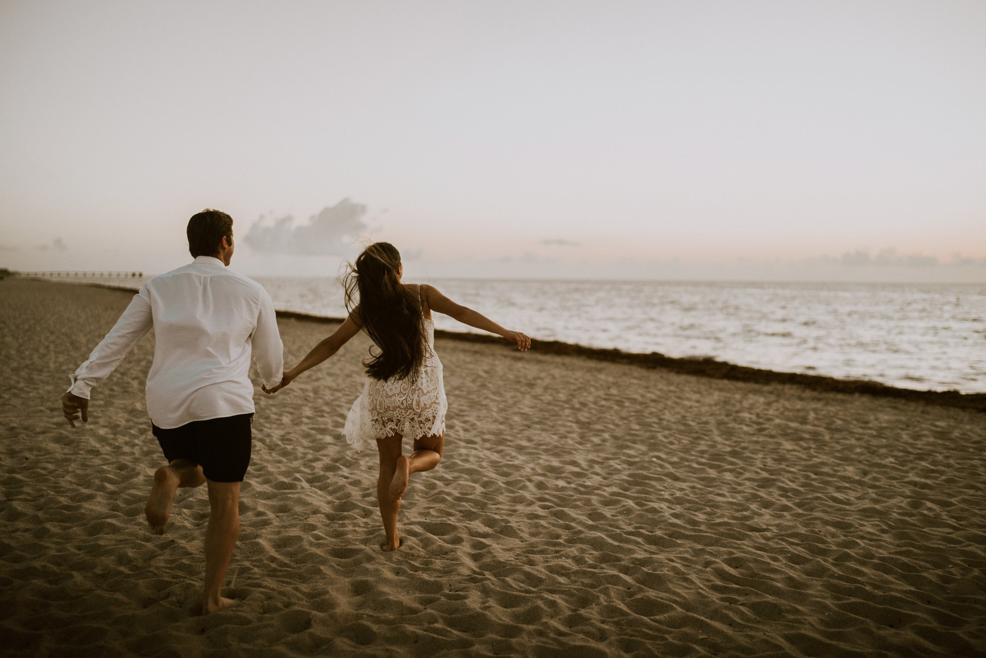 couple running on Miami Beach during sunrise